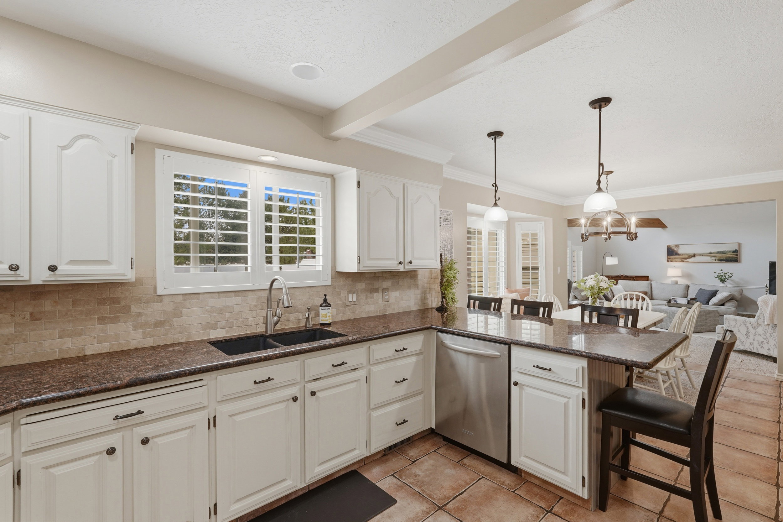 Kitchen featuring white cabinetry, dark speckled countertops, and a subway tile backsplash