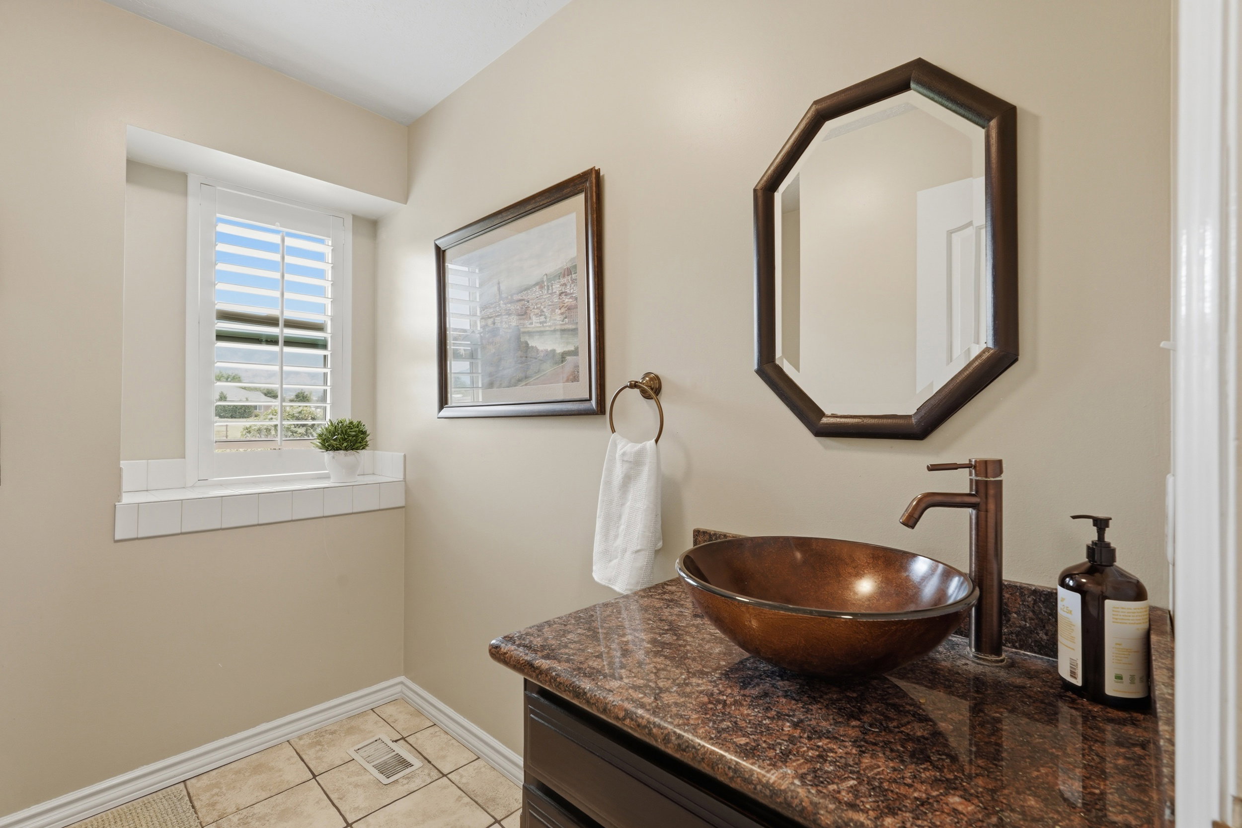 Powder room featuring a vessel sink, oil-rubbed bronze faucet, and a brown speckled countertop