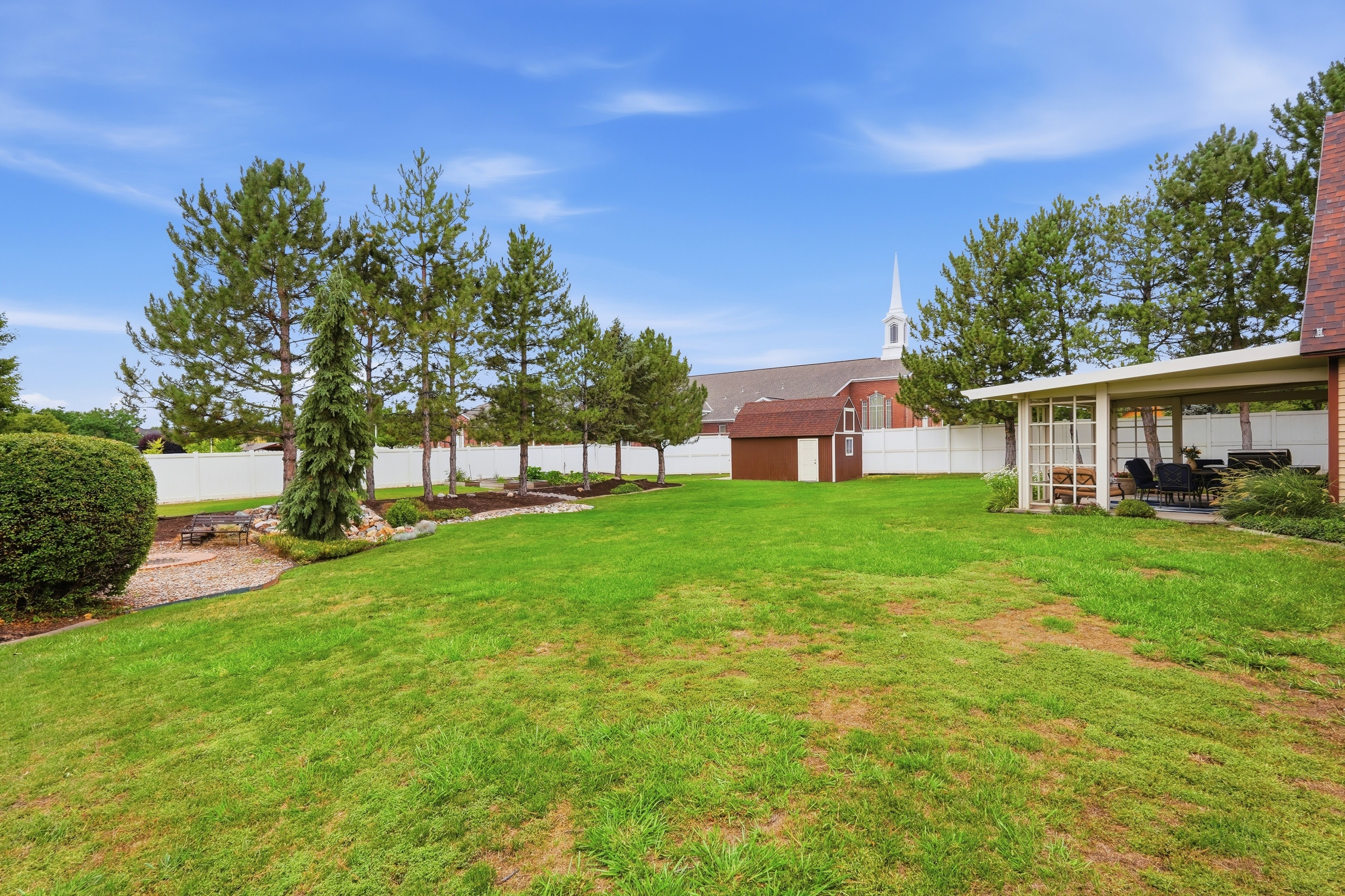 Expansive green lawn with a covered patio area