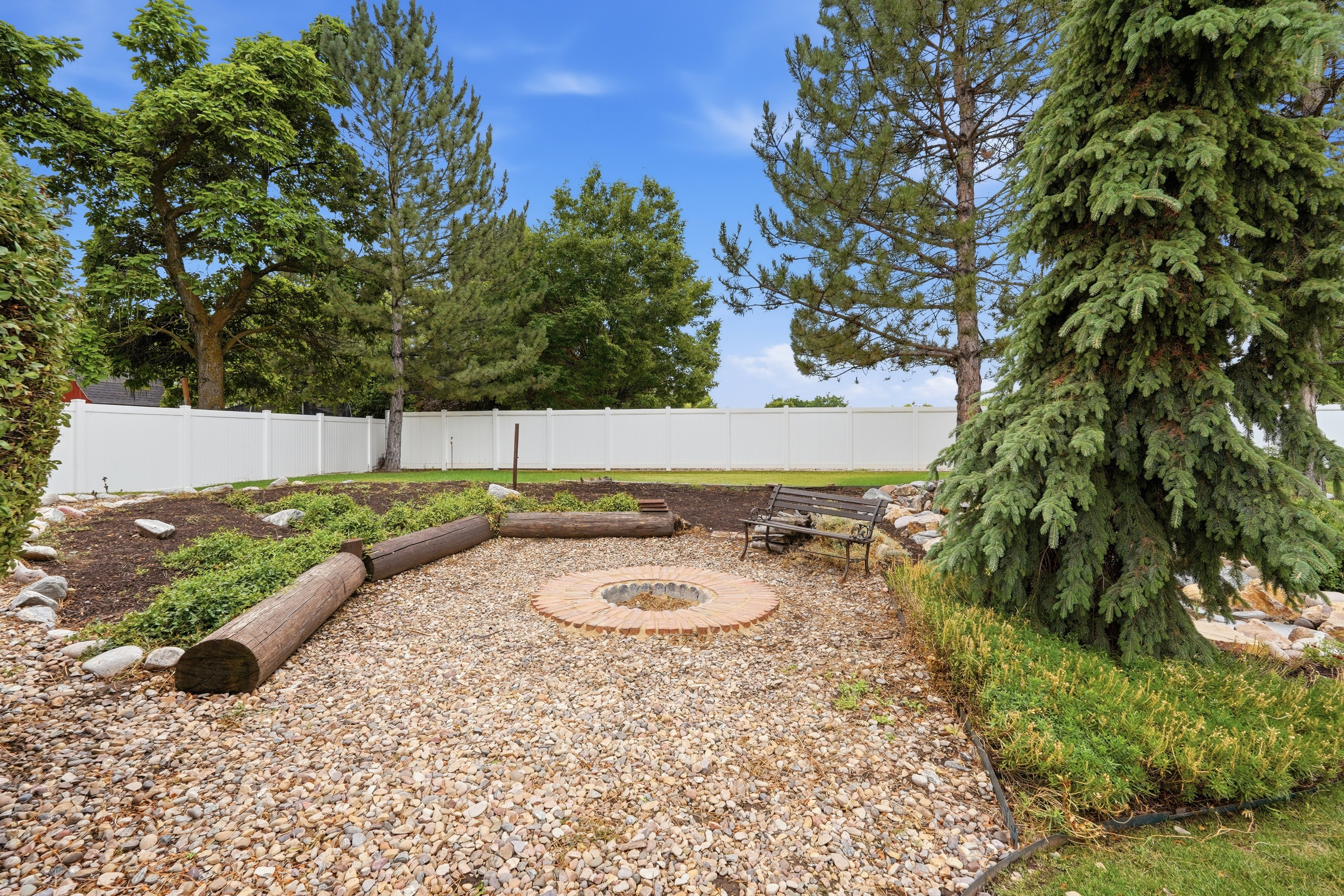 Gravel hardscaping surrounding a circular brick-lined fire pit