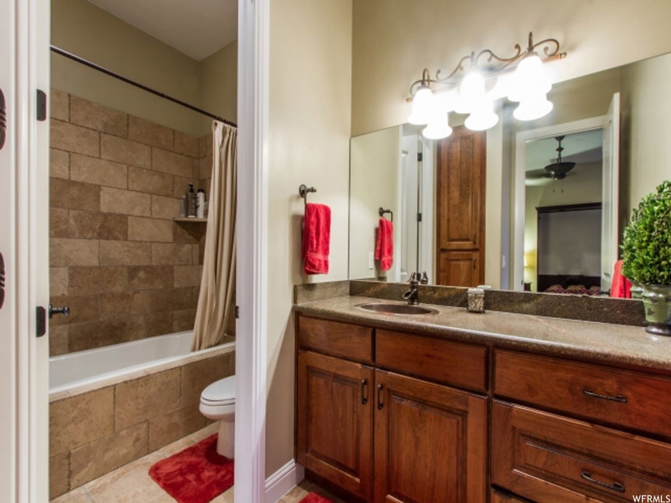 Bathroom vanity with a dark wood-finish cabinet, integrated sink, and stone-finish countertop