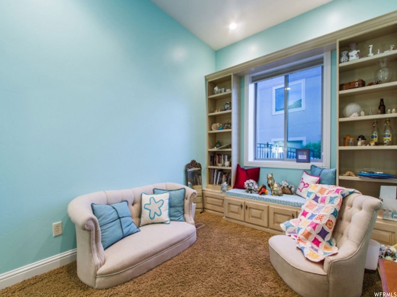 Built-in window seat featuring integrated cabinetry and flanking open shelving units