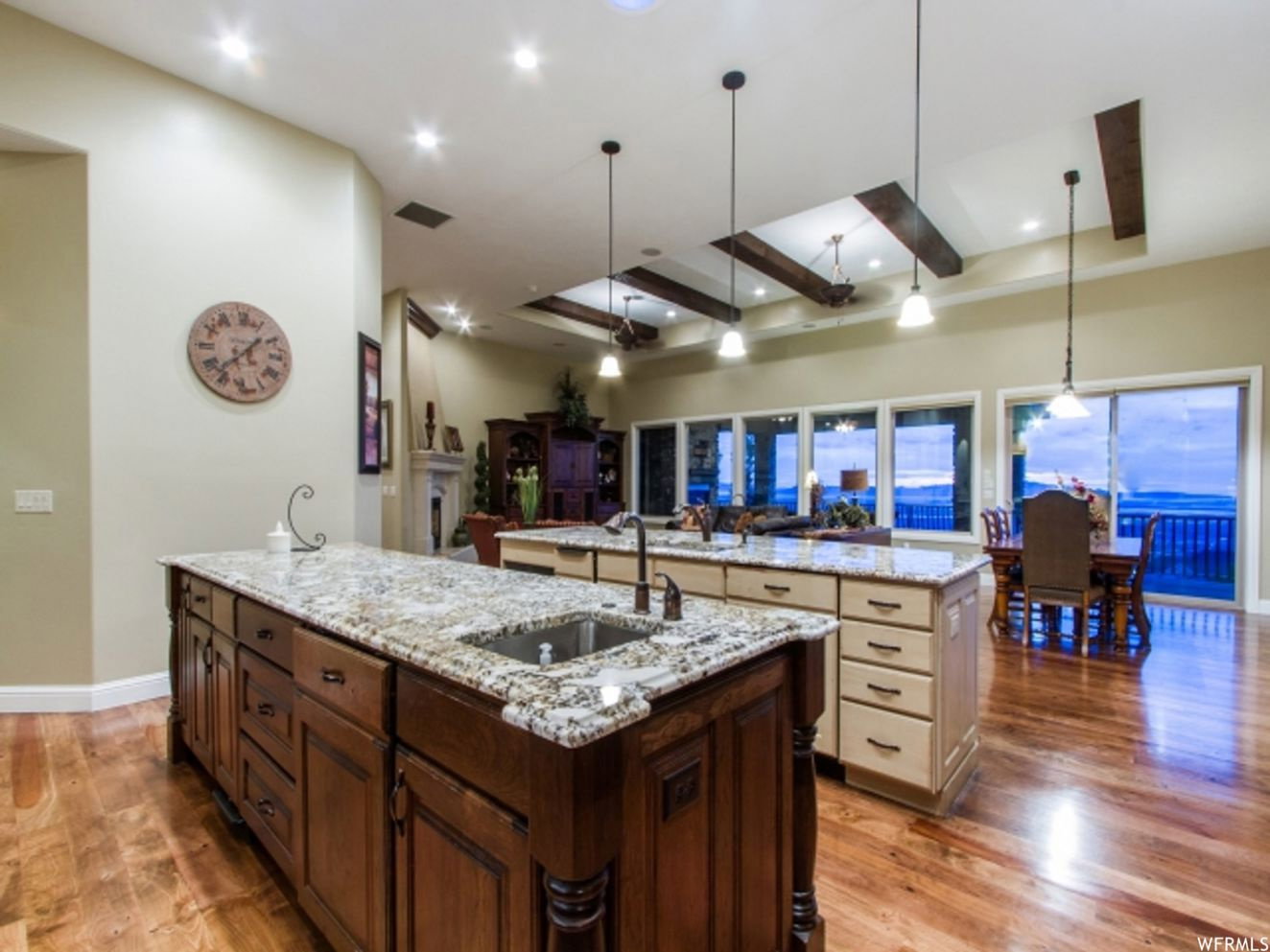 Kitchen featuring dual islands with granite countertops, integrated sink, and wood-finish flooring