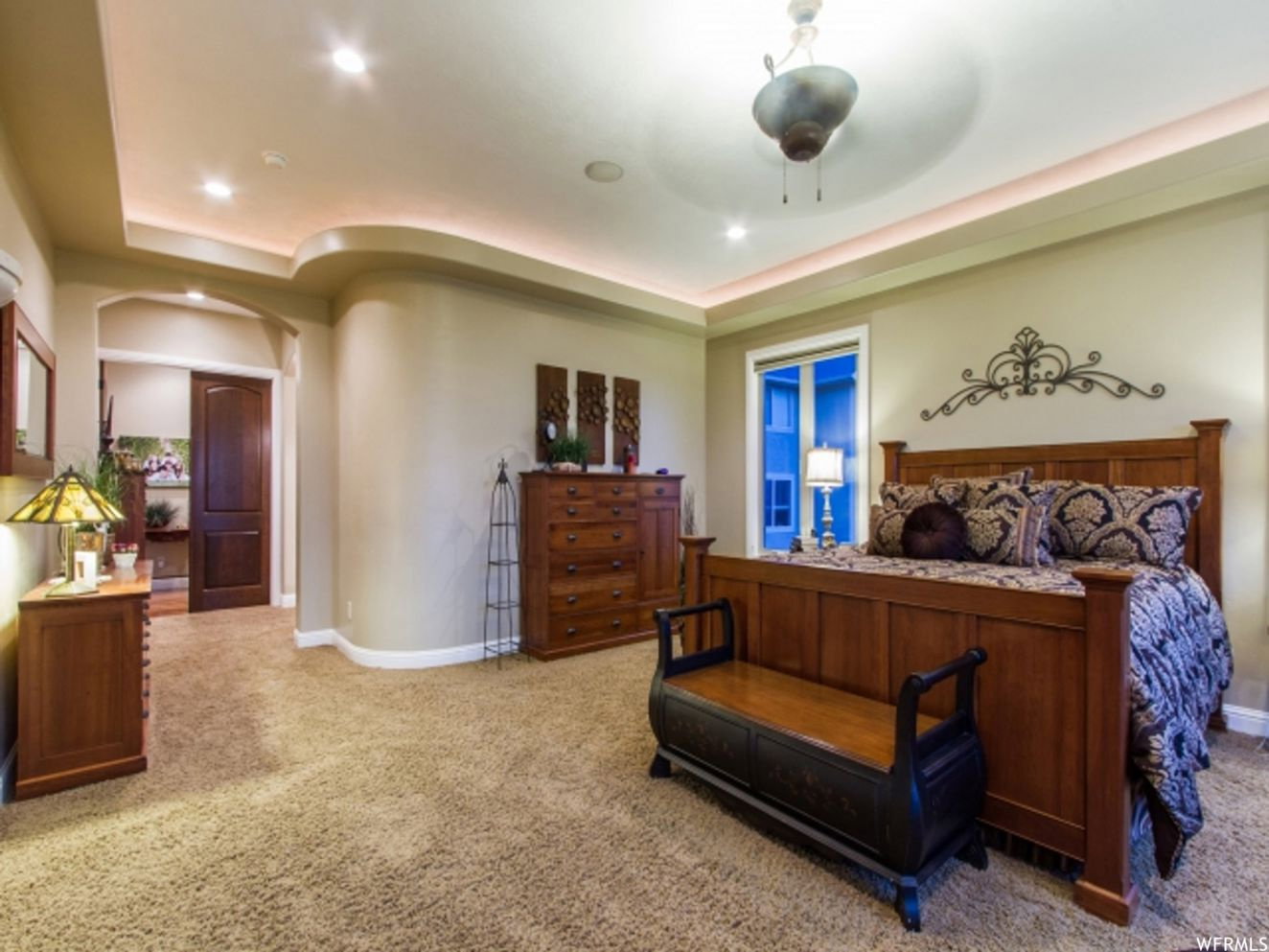 Carpeted room featuring a tray ceiling with cove lighting and recessed fixtures