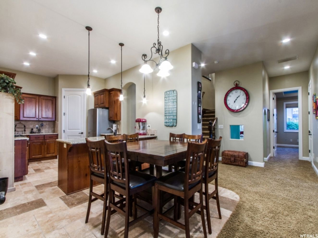 Kitchen and dining area featuring varied flooring, recessed lighting, and a chandelier