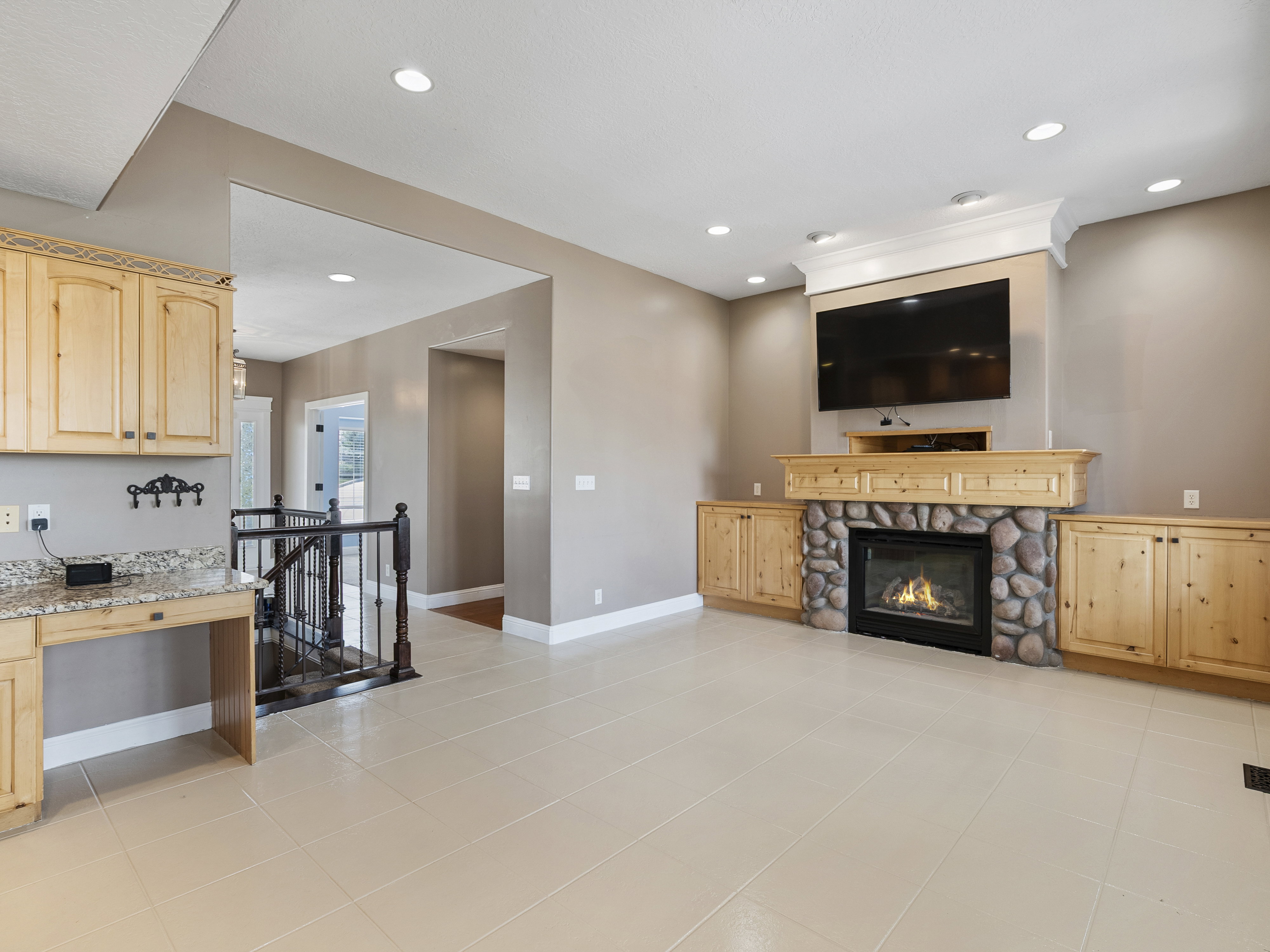 Stone-faced fireplace with a wood mantle and surrounding built-in cabinetry