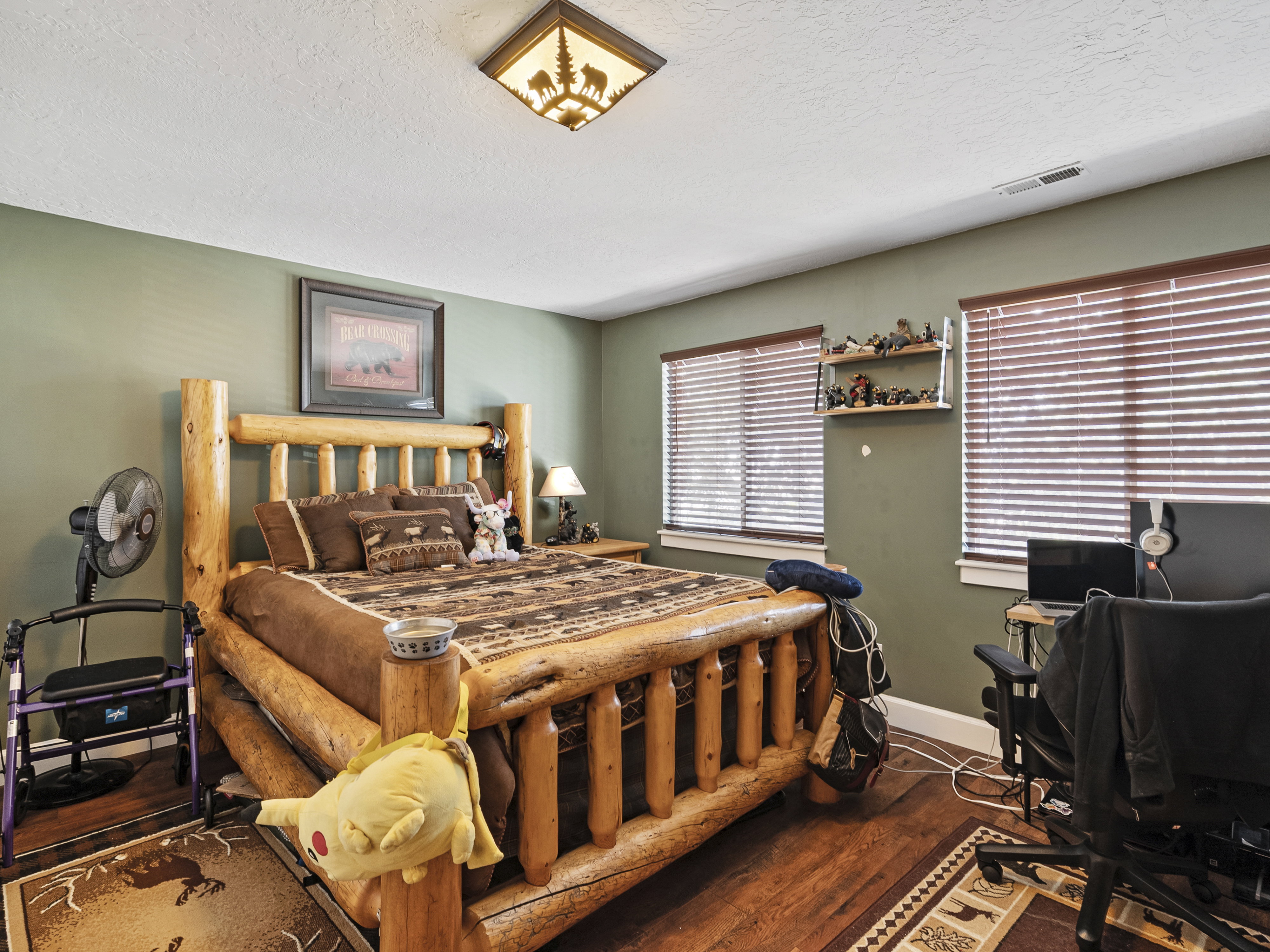 Bedroom featuring wood-finish flooring and a log-style bed frame