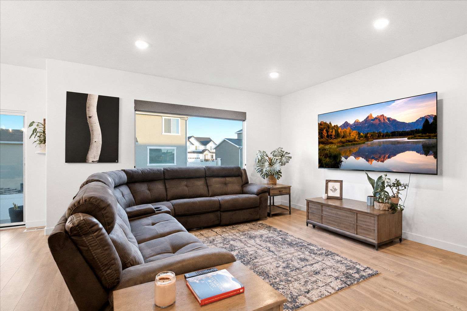 Open living area featuring wood-finish flooring, recessed lighting, and large windows