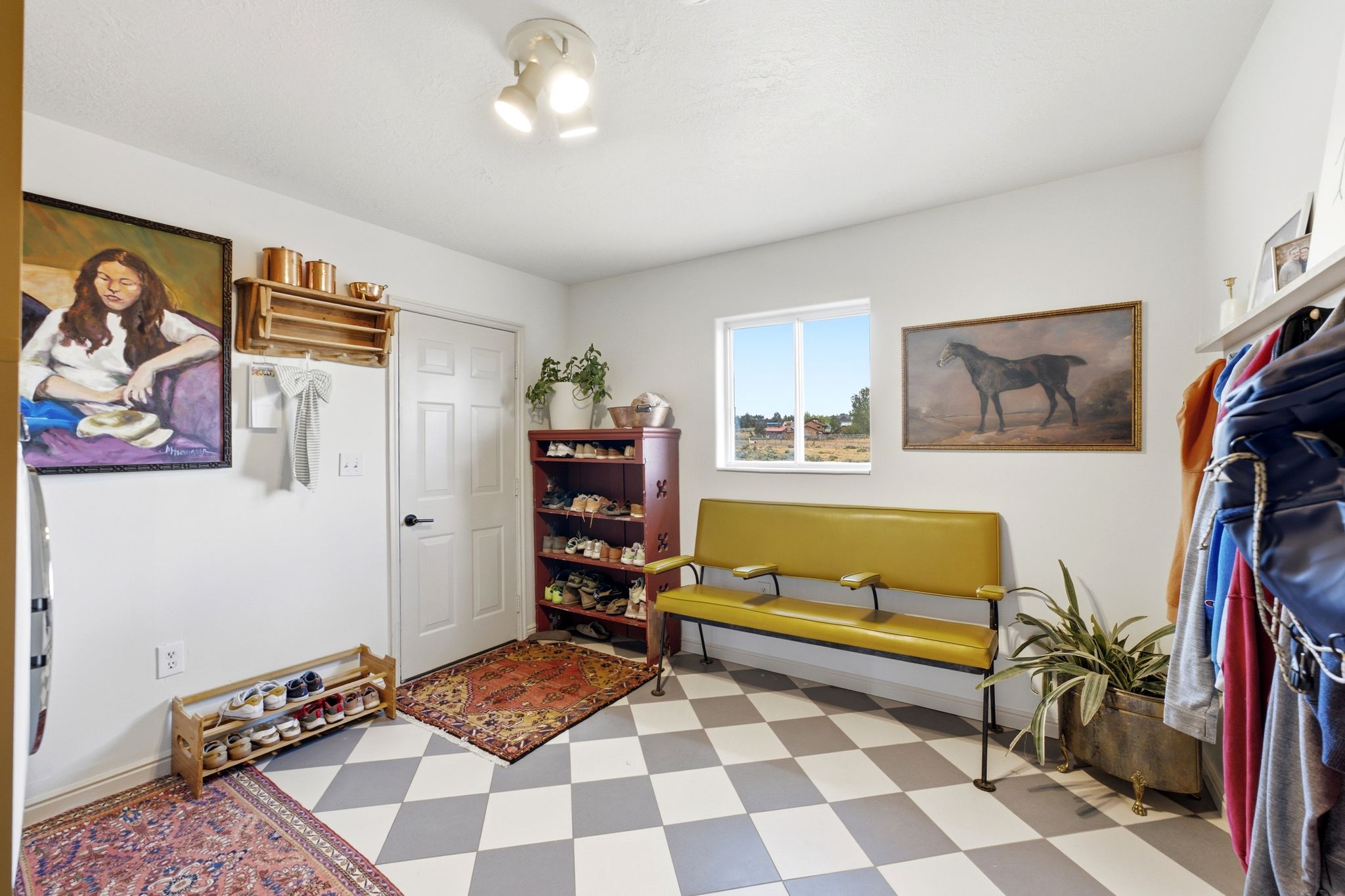 Entryway featuring checkerboard flooring, a white paneled door, and a single window providing natural light