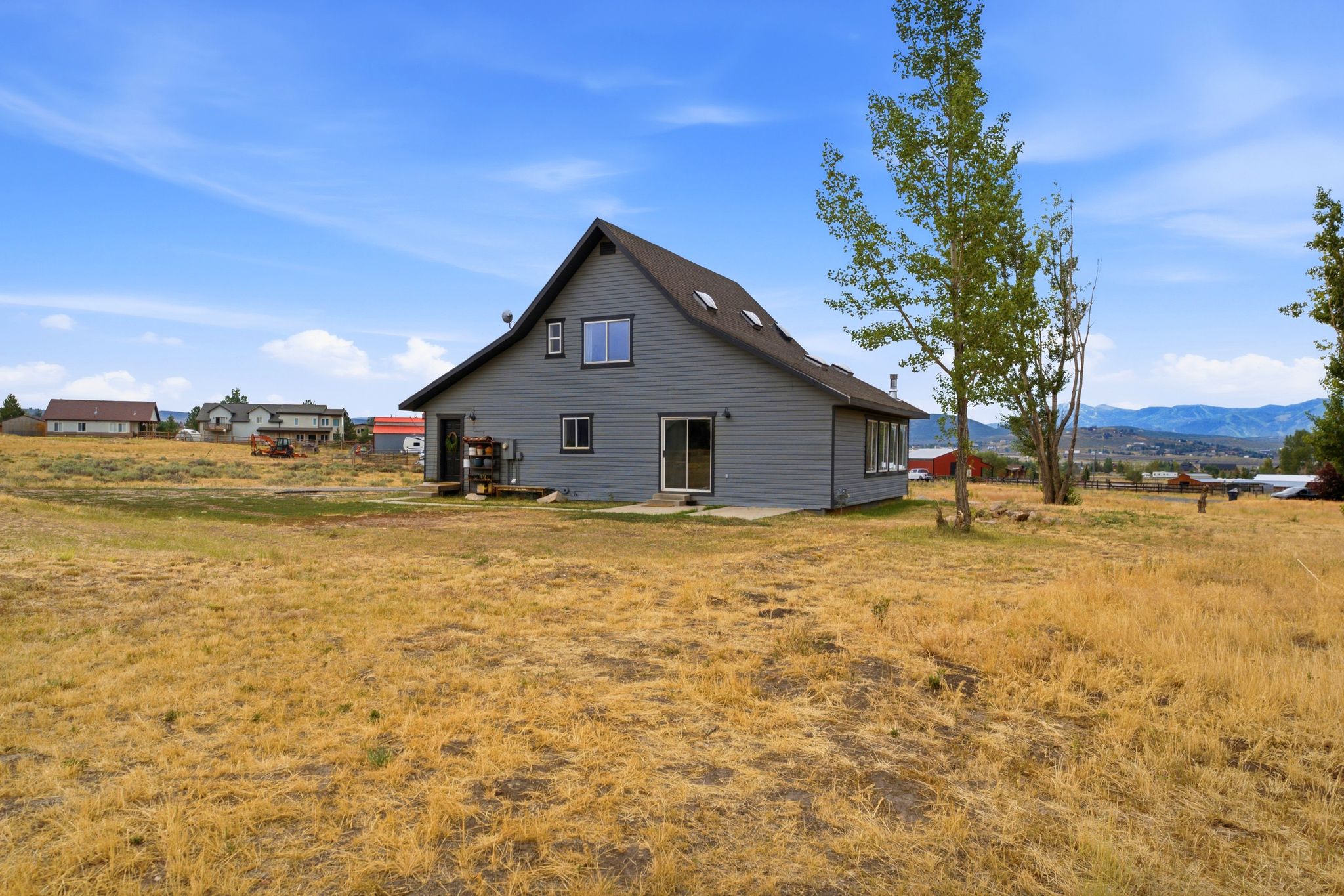 Grey siding exterior with a dark roof and multiple windows