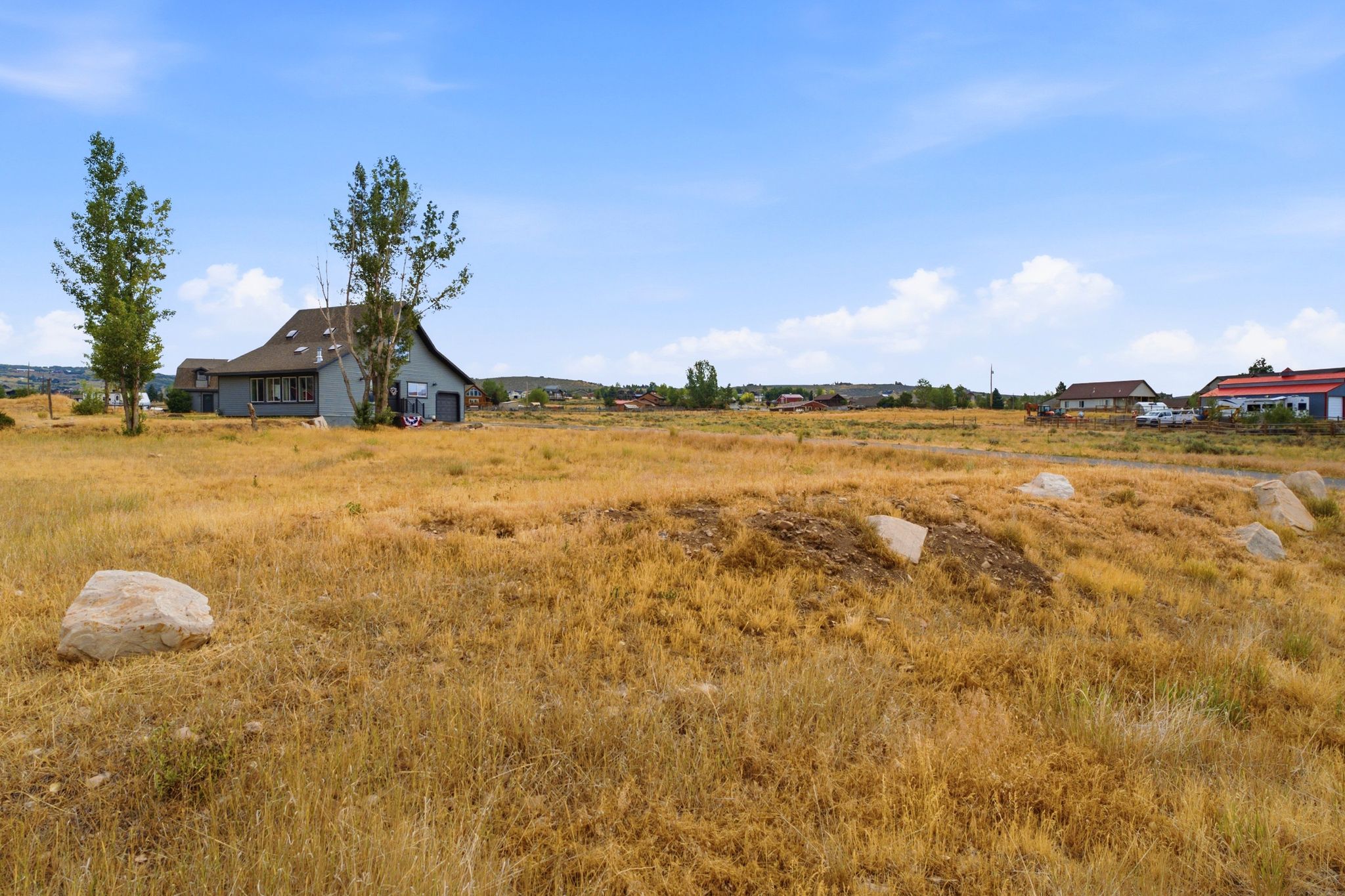 Expansive lot featuring a contemporary barn-style residence with a dark roof and light gray siding