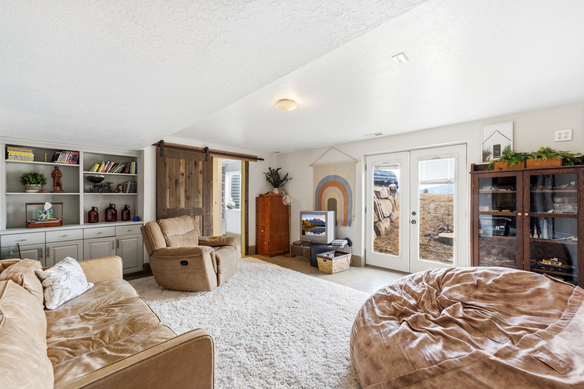 Spacious living area featuring light-toned carpeting and recessed lighting
