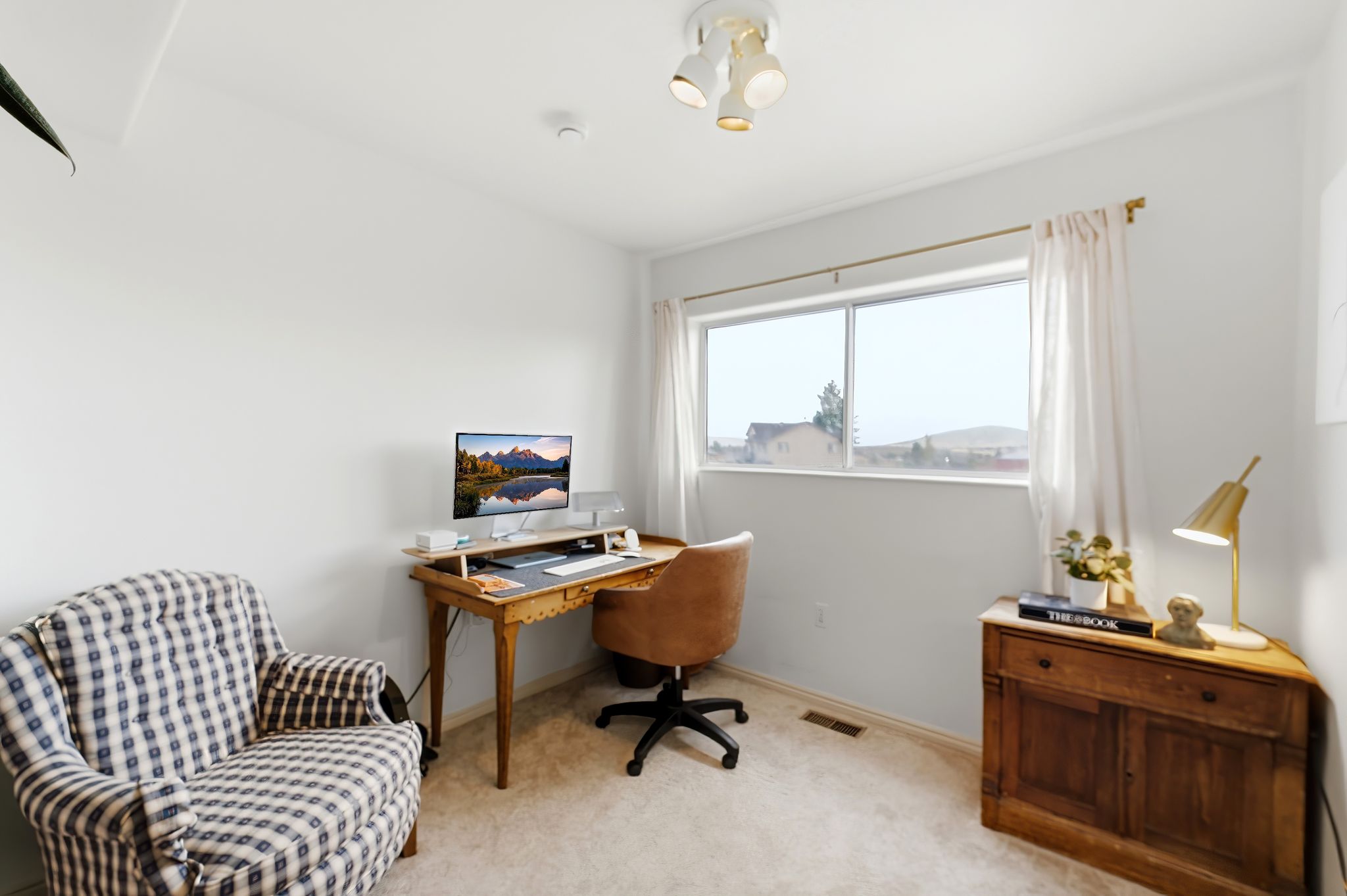 Bright room with neutral wall paint and carpeted flooring