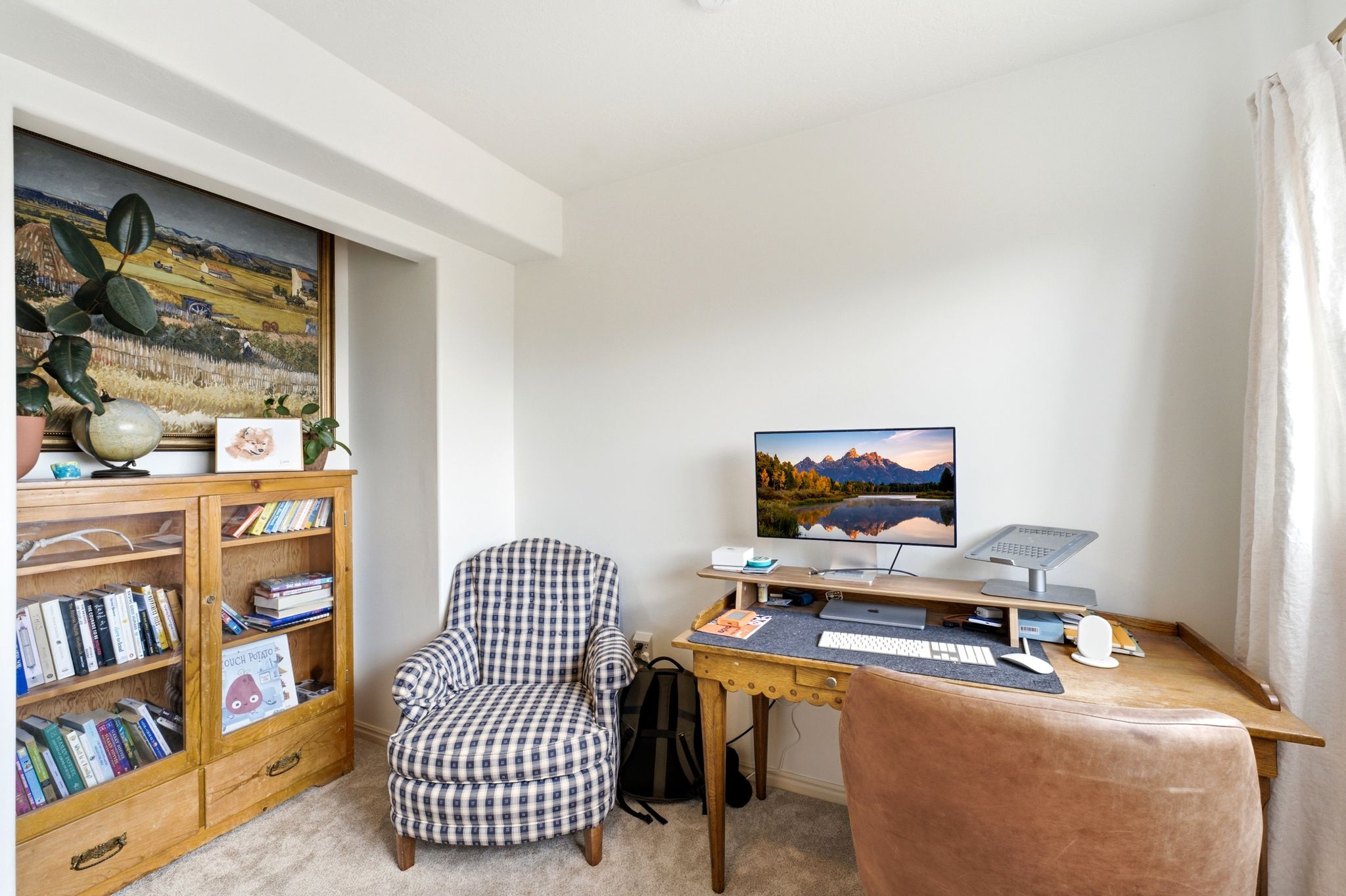 Recessed wall niche, light-colored carpeting, and window with sheer drapery