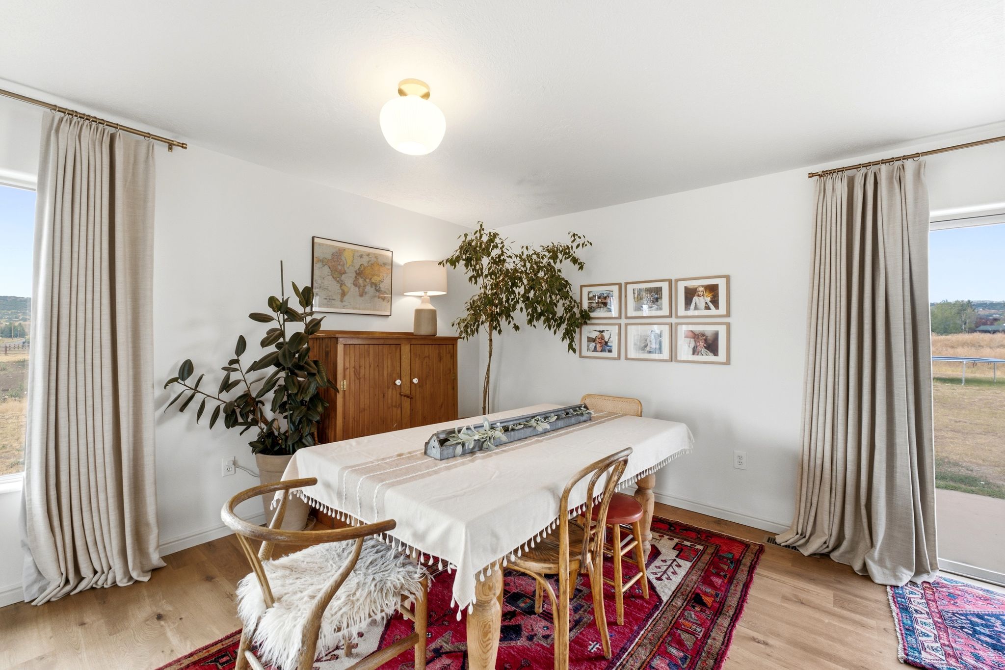 Bright interior space featuring light wood-finish flooring, white walls, and a contemporary ceiling light fixture