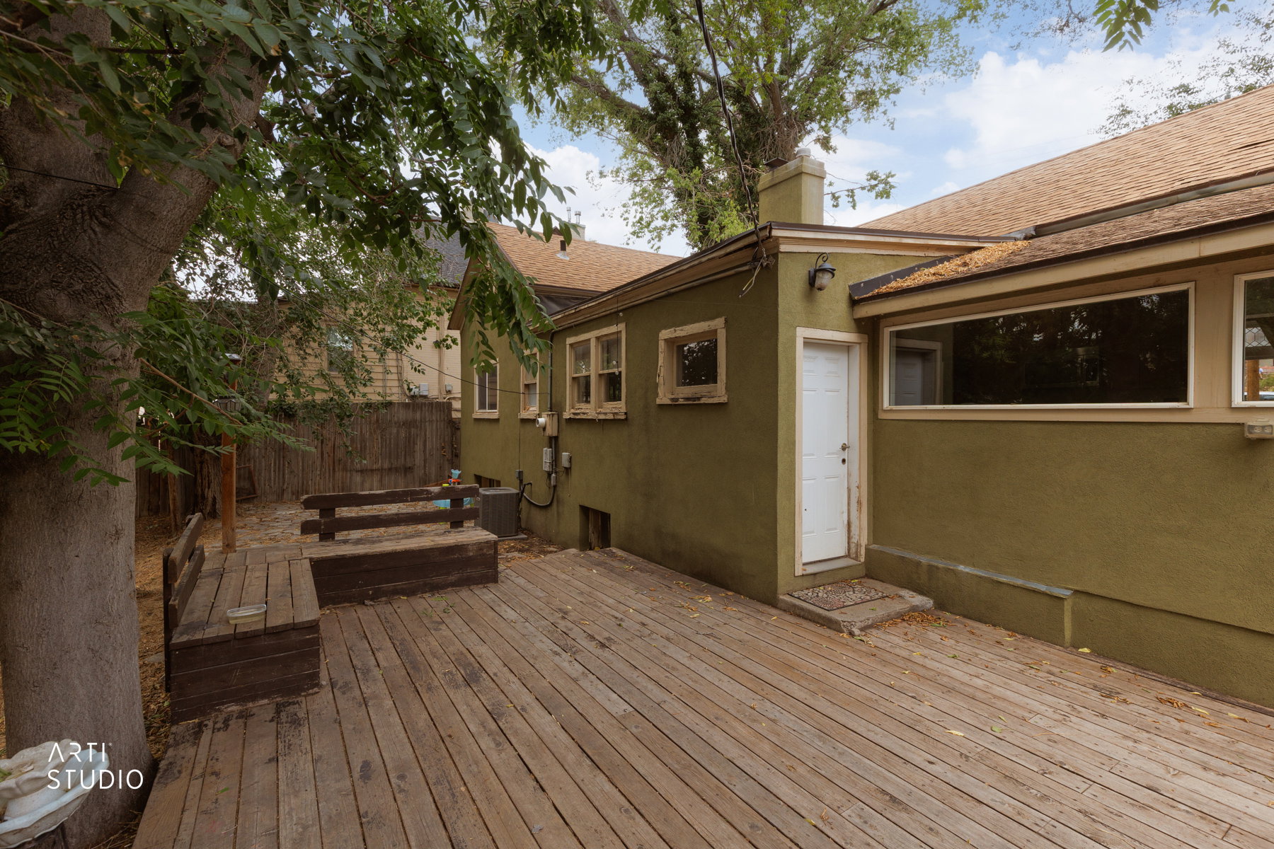 Wood-finish decking extends from the rear entry, featuring built-in bench seating