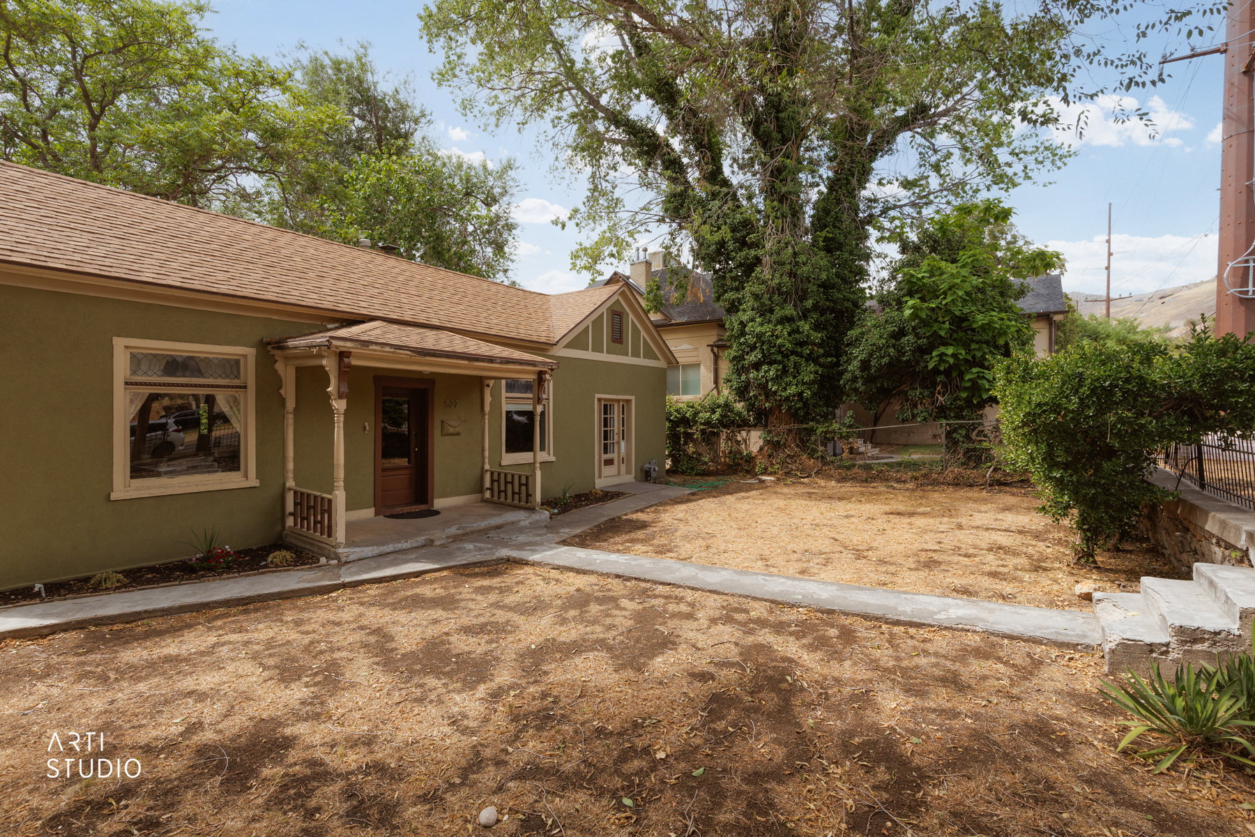Olive green exterior with a covered front porch featuring decorative columns