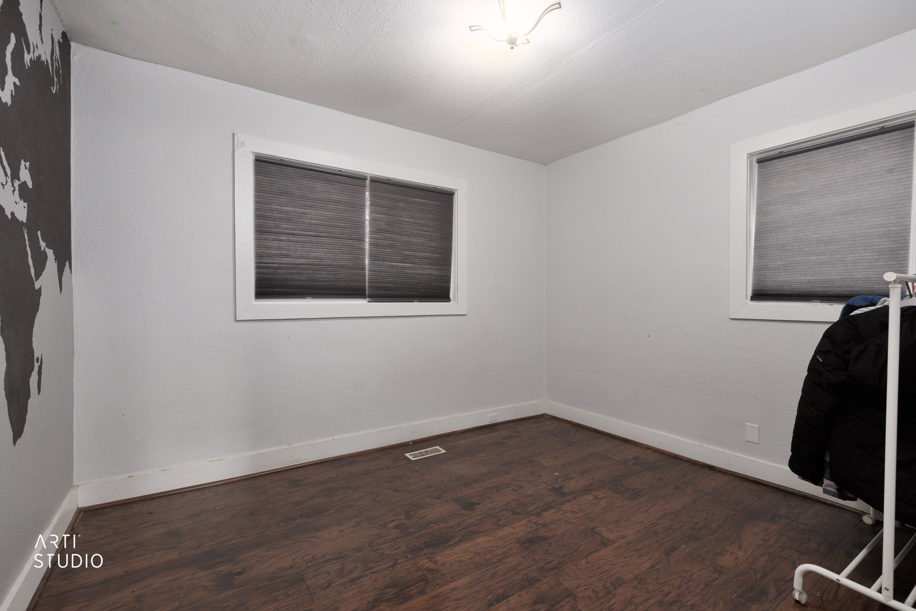 Room featuring wood-finish flooring, white baseboards, and light-toned walls