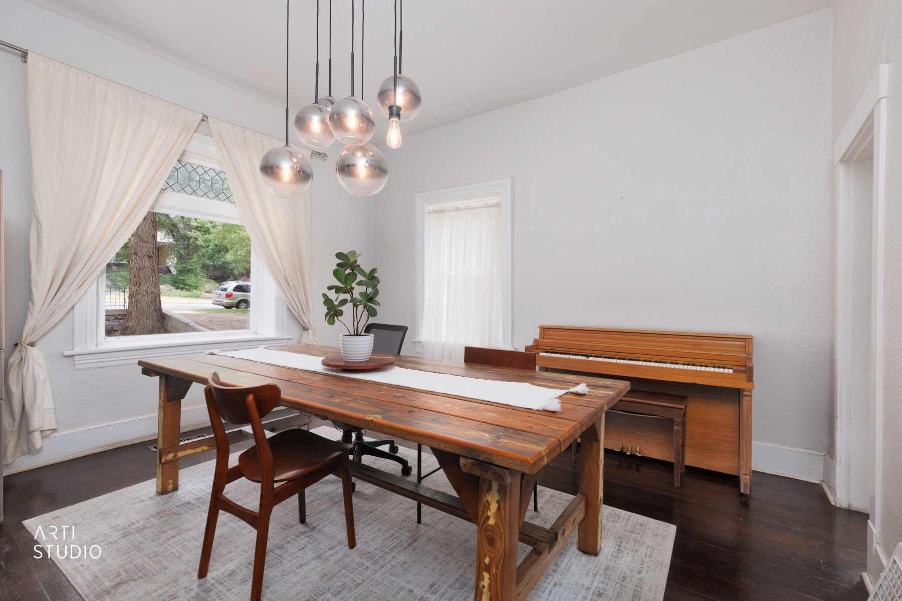 Spacious interior room featuring dark wood-finish flooring, white wall tones, and white trim throughout