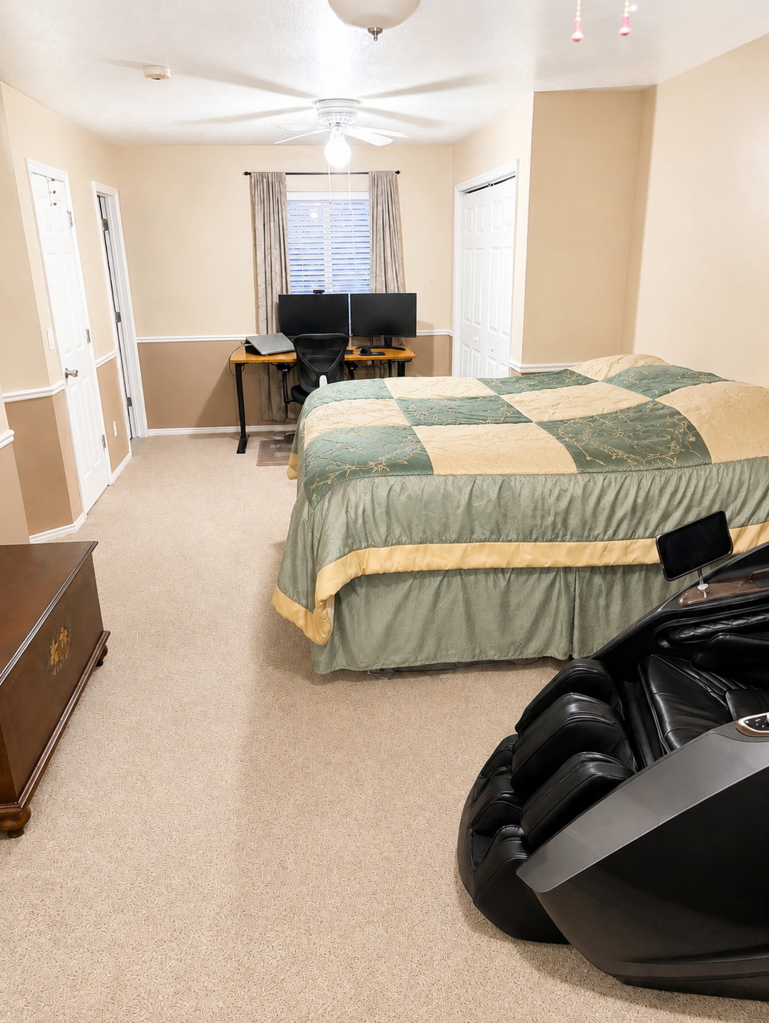 Carpeted room featuring a ceiling fan, window with blinds and curtains, and two panel doors