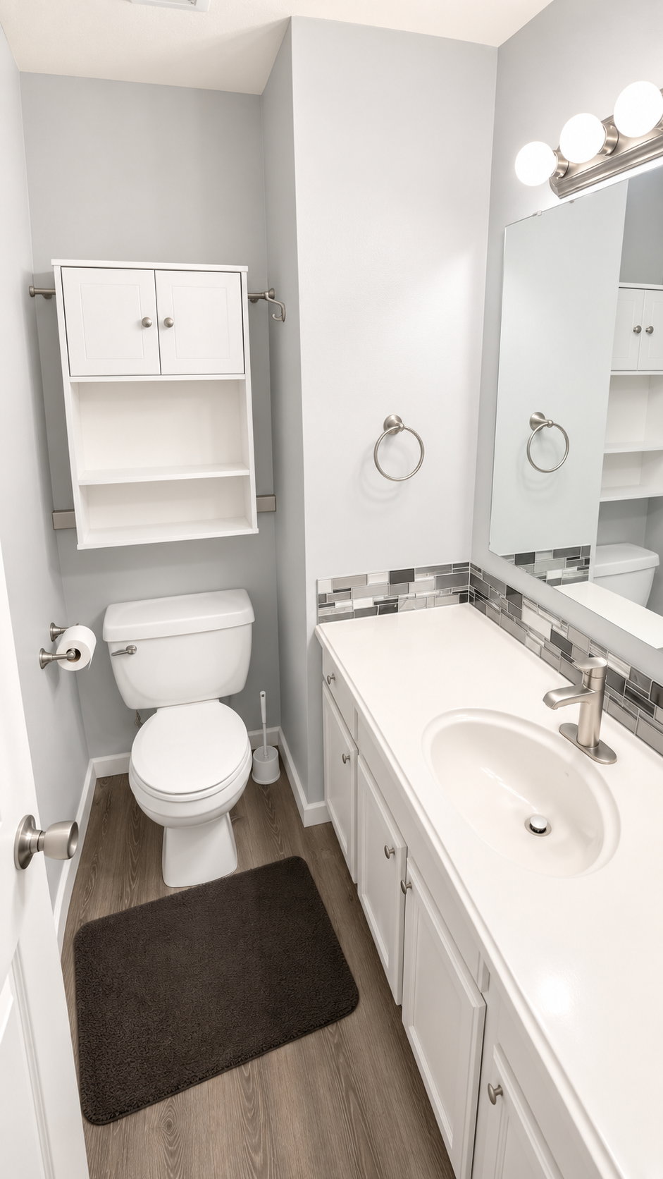 Bathroom featuring a white vanity with integrated sink, brushed nickel faucet, and mosaic tile backsplash
