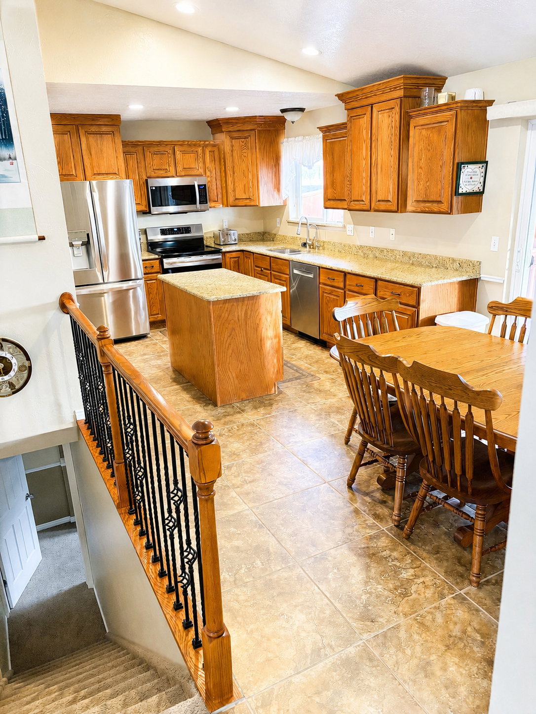 Kitchen featuring wood cabinetry, stainless steel appliances, a kitchen island with a stone countertop, recessed lighting, and tile flooring