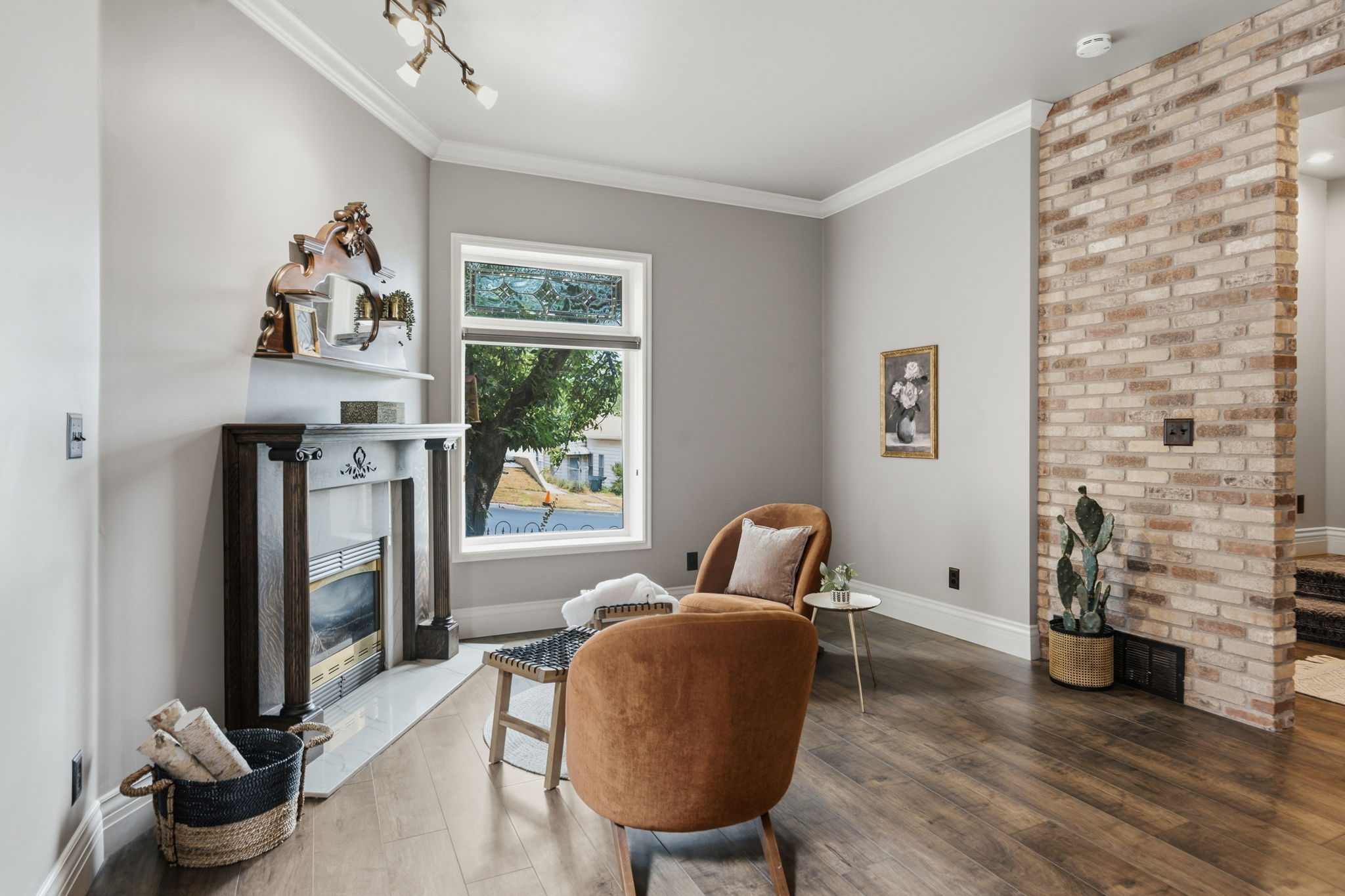 Interior space featuring wood-finish flooring, a decorative fireplace with an ornate mantel, and crown molding