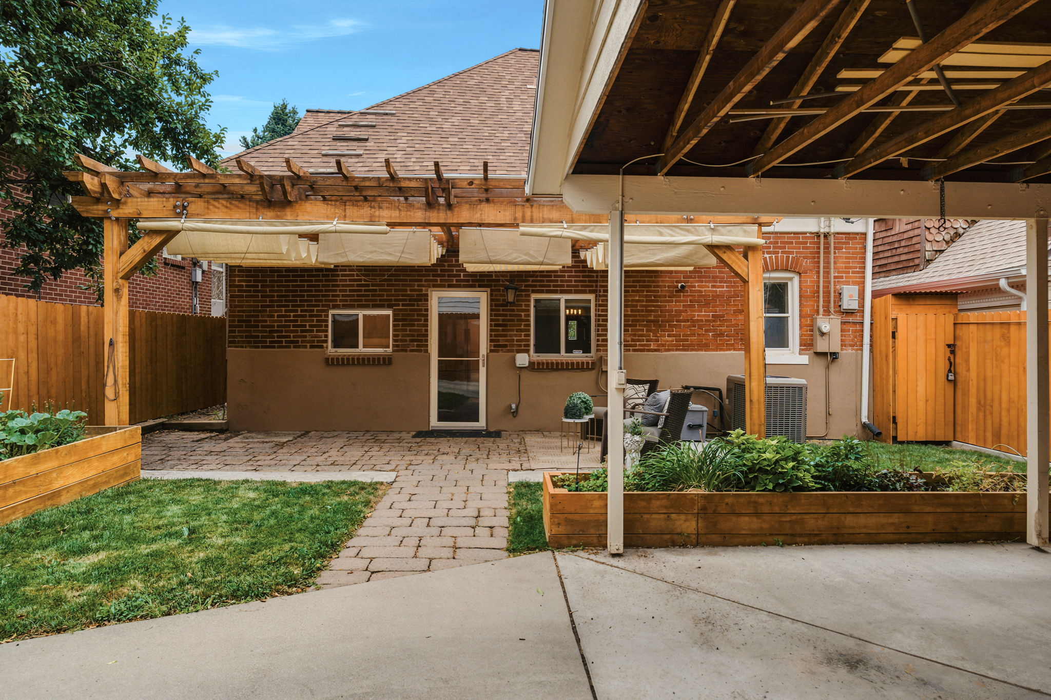 Brick exterior with a covered patio area and paved walkway