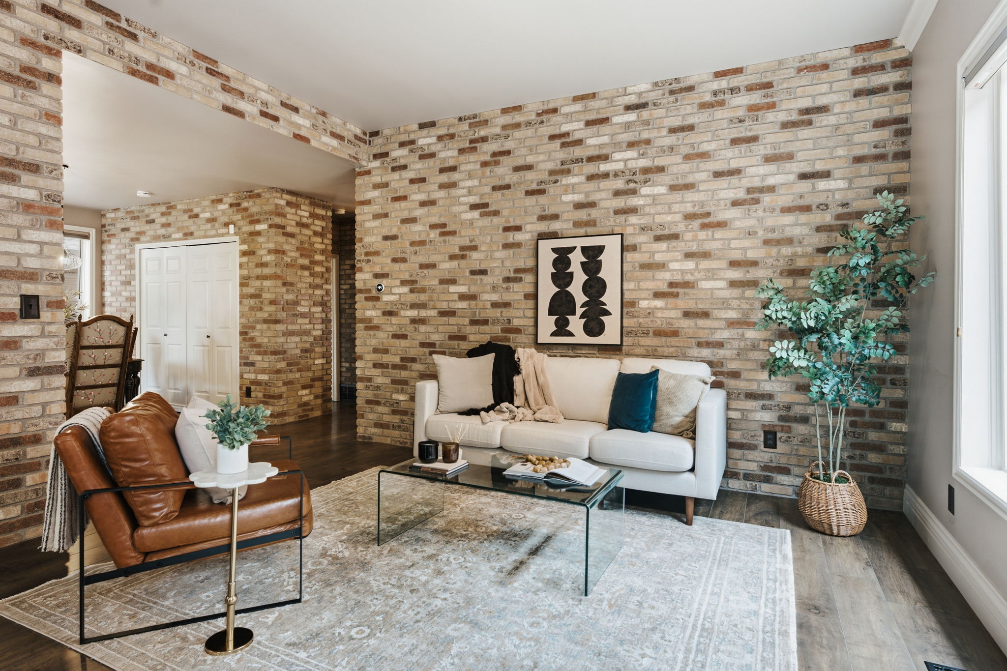 Exposed brick accent walls throughout the living area, complemented by wood-finish flooring