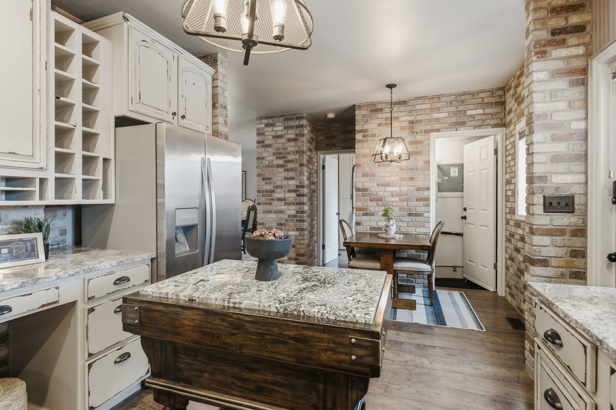 Kitchen featuring a wood-finish floor and exposed brick accents