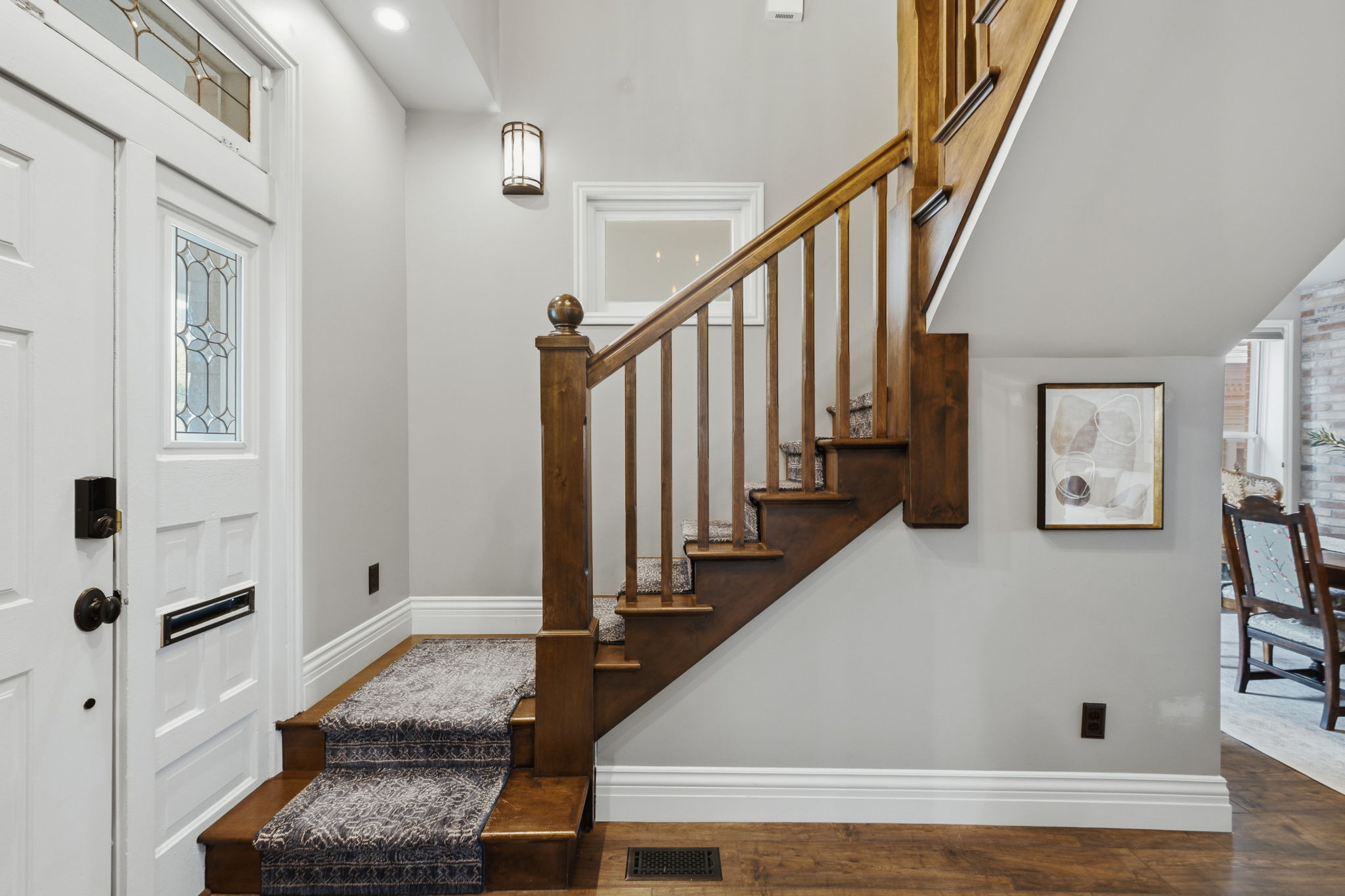 Front entry featuring a white paneled door with decorative glass inserts and a transom window