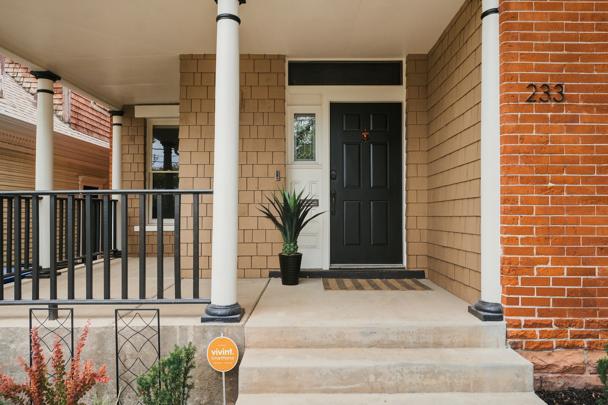 Inviting covered porch with robust white columns and a black metal railing