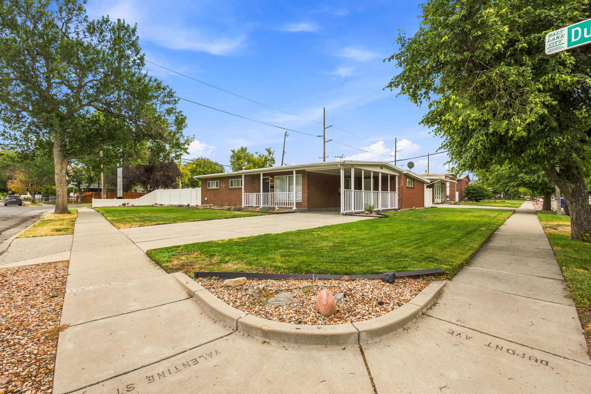 Brick exterior residence with a covered carport and front porch featuring white railings