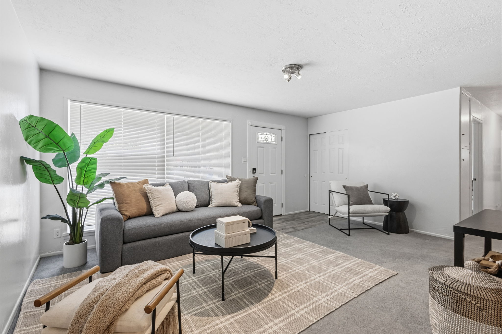 Light-filled living area featuring neutral wall tones and a window with blinds