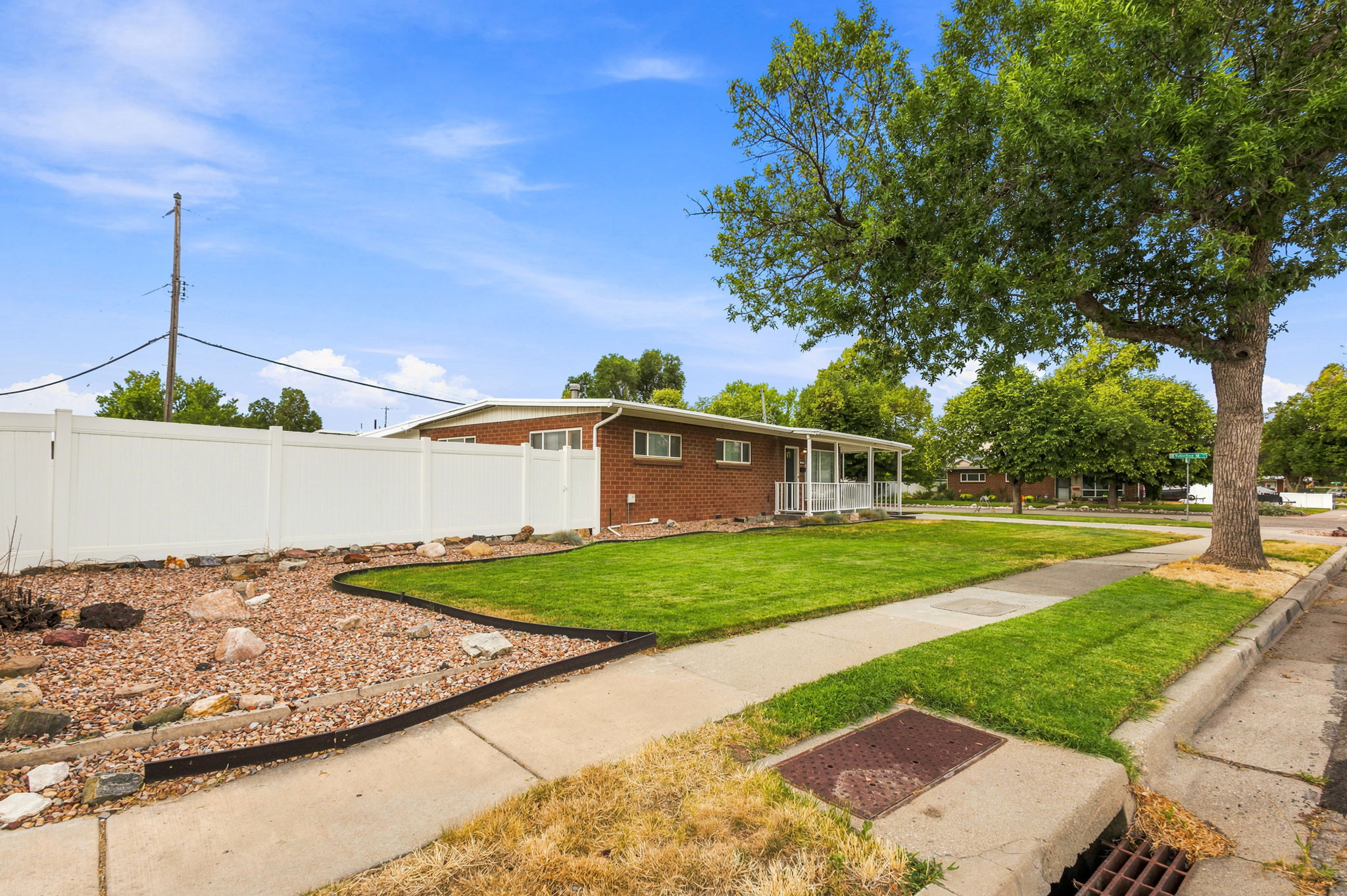 Brick ranch-style home featuring a covered front porch with white railing