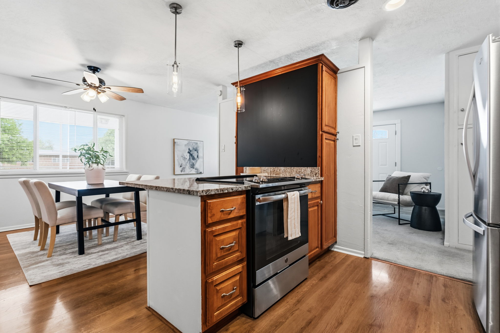 Kitchen island with a granite-style countertop, integrated stainless steel range, and wood-finish cabinetry
