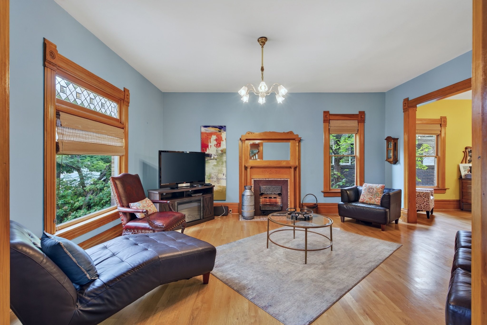 Hardwood flooring throughout featuring a decorative fireplace with a wood surround and mantle
