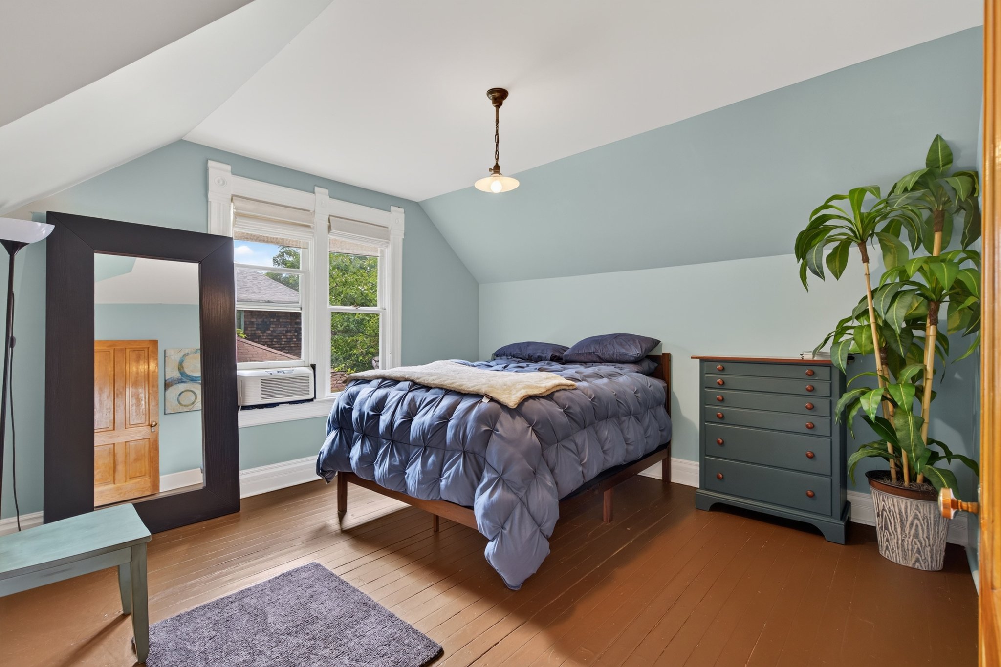 Attic room featuring painted wood-finish flooring and sloped ceilings