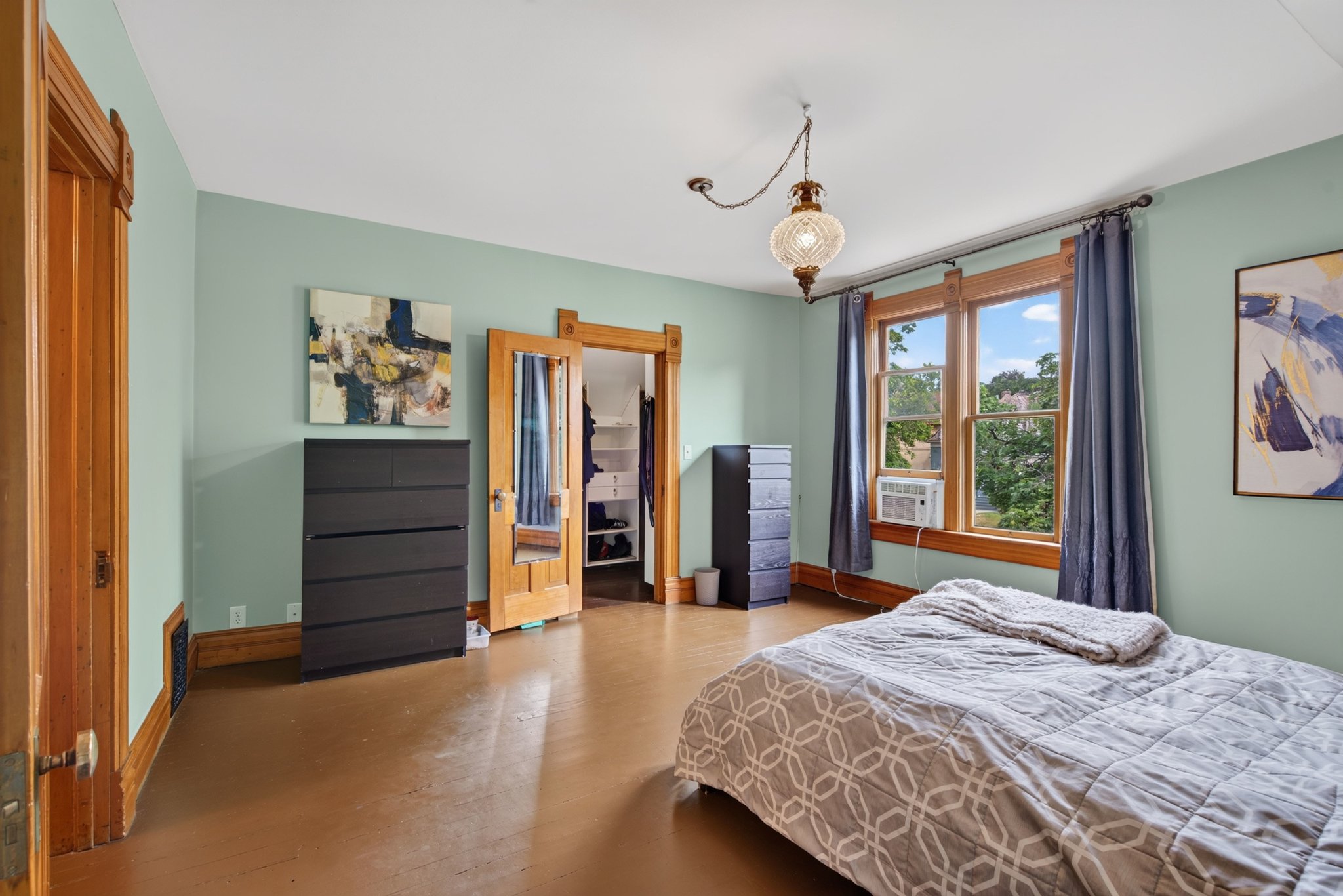 Room featuring prominent window frames and trim in a natural wood finish, complemented by a light green wall color