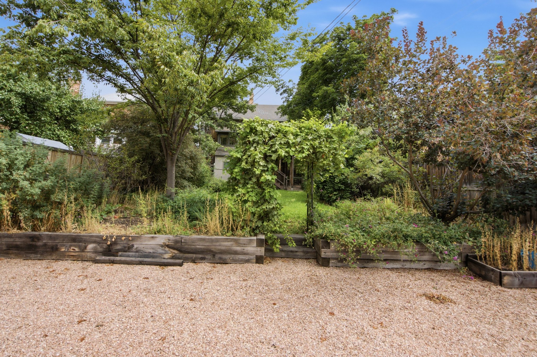 Expansive gravel area with wood-finish retaining walls
