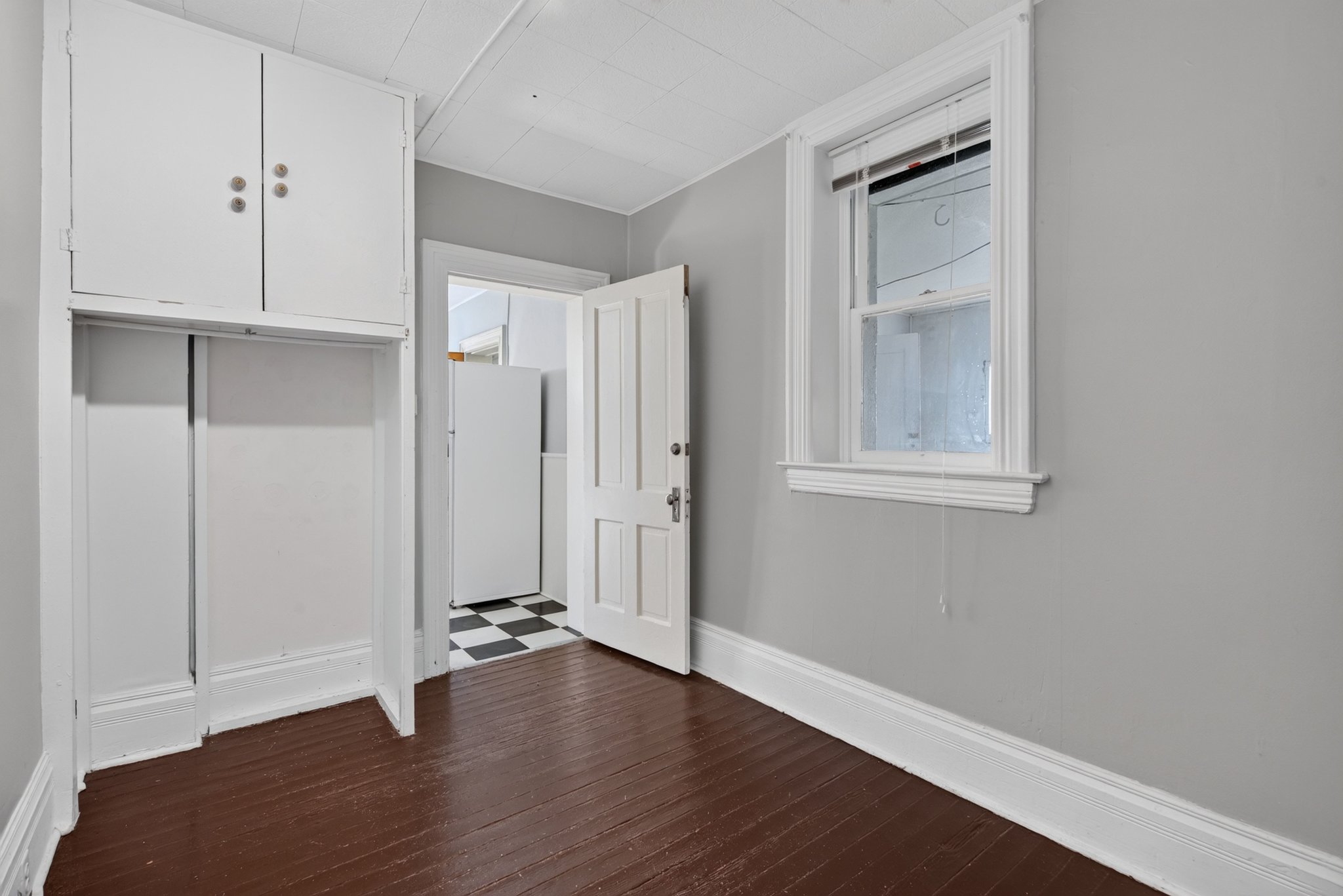 Brown wood-finish flooring with white trim and light gray walls