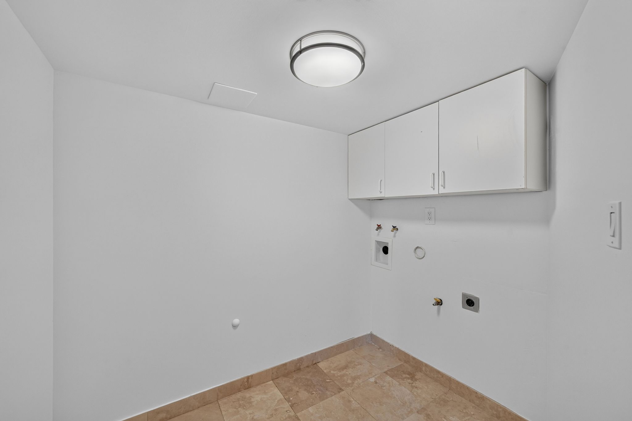 Utility space with light beige tile flooring, white walls, and a contemporary ceiling light fixture