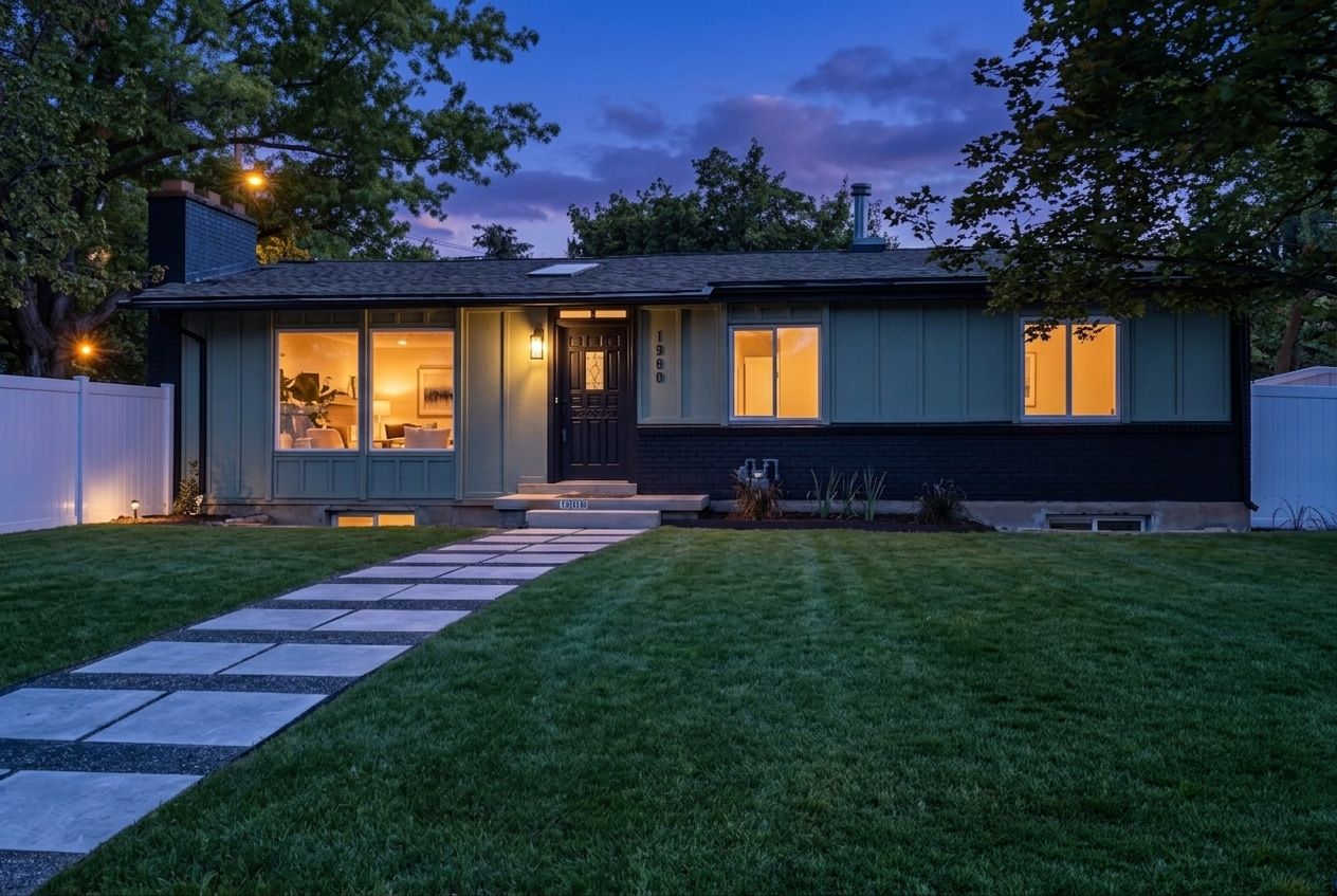 Contemporary single-story residence featuring a well-maintained lawn, a stepping stone walkway leading to the entrance, and a white privacy fence