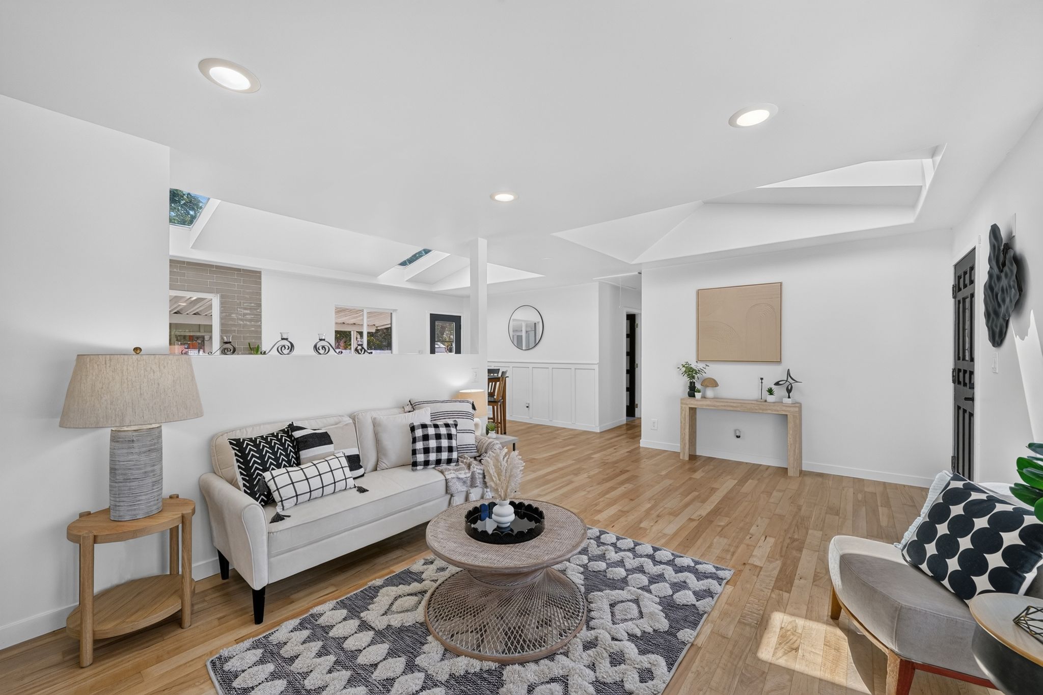 Spacious living area featuring light wood-finish flooring and recessed lighting