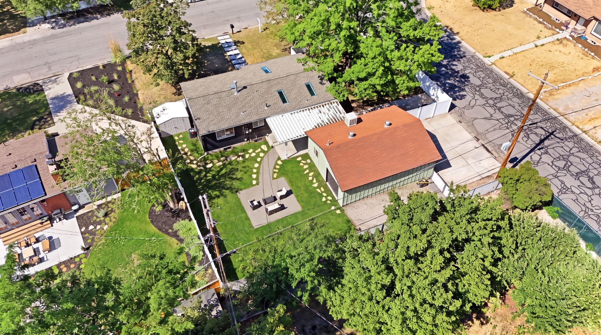 Expansive landscaped backyard featuring a curvilinear stepping stone path, a dedicated patio area, and mature trees providing natural screening