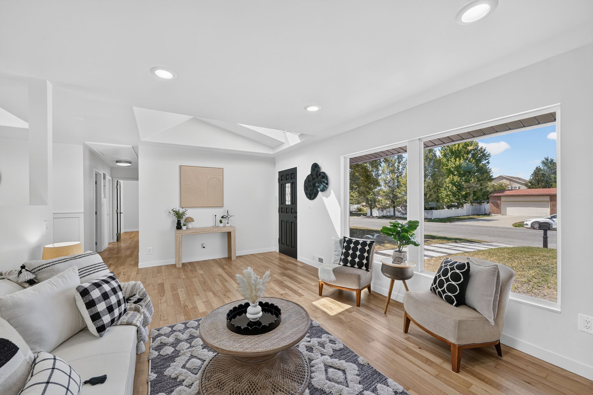 Expansive living area featuring wood-finish flooring, recessed lighting, and large picture windows