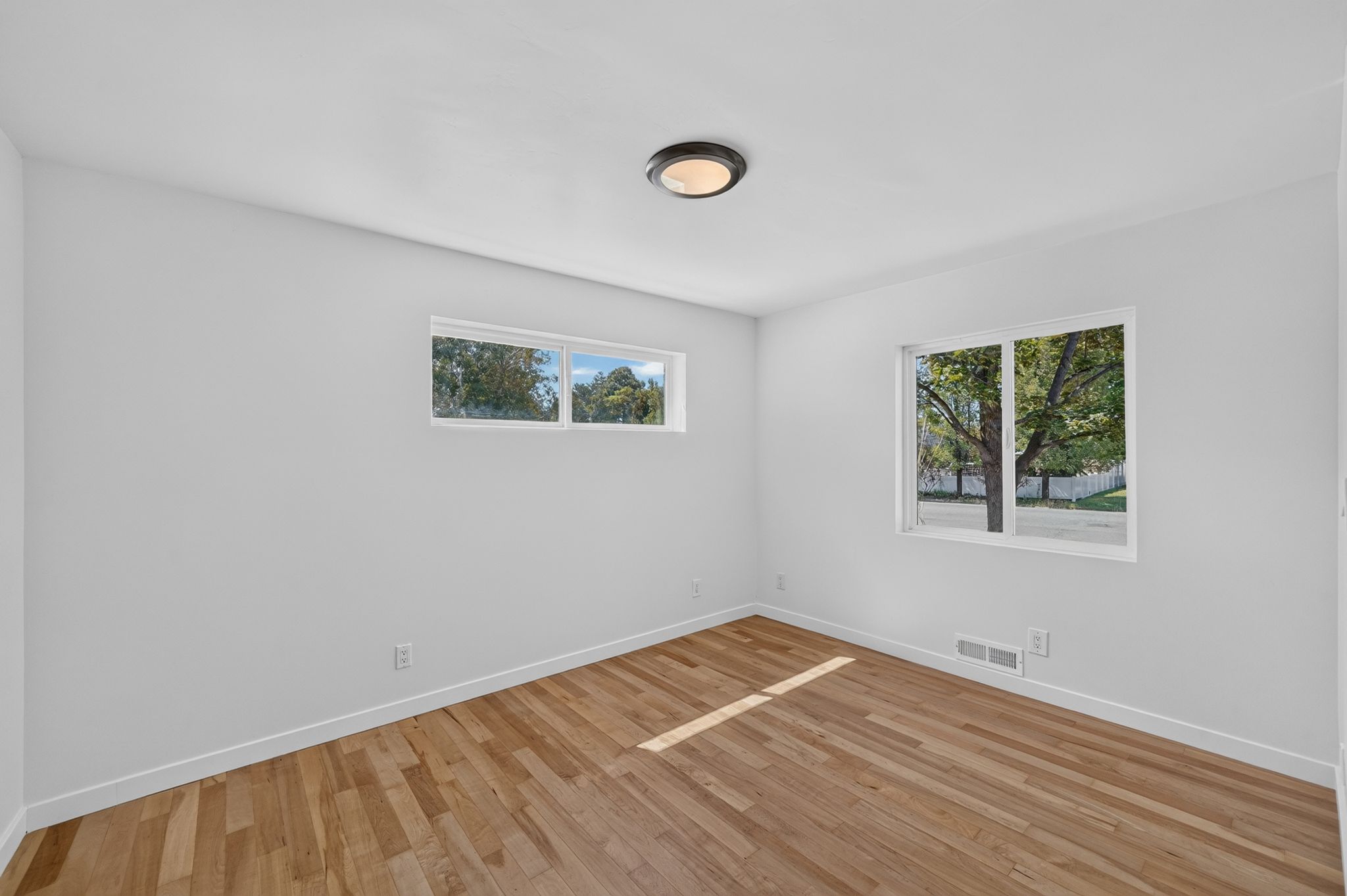 Interior room with light wood-finish flooring, white walls, and white baseboards