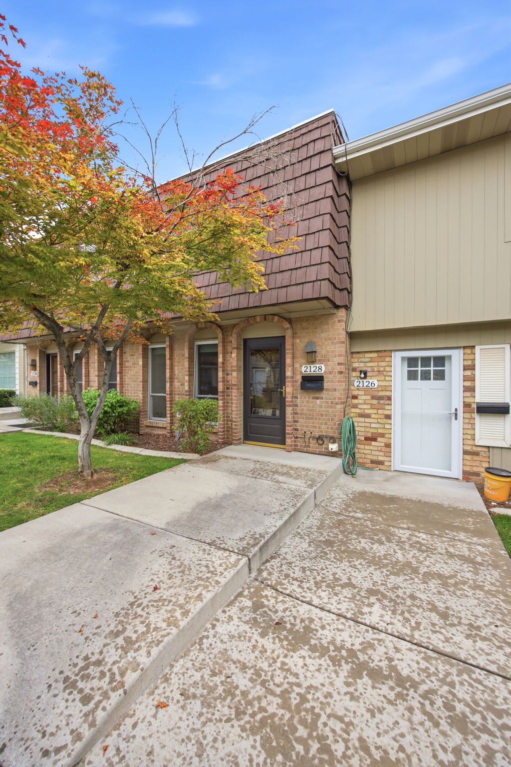Brick exterior facade with a prominent dark brown front door and an integrated address plaque