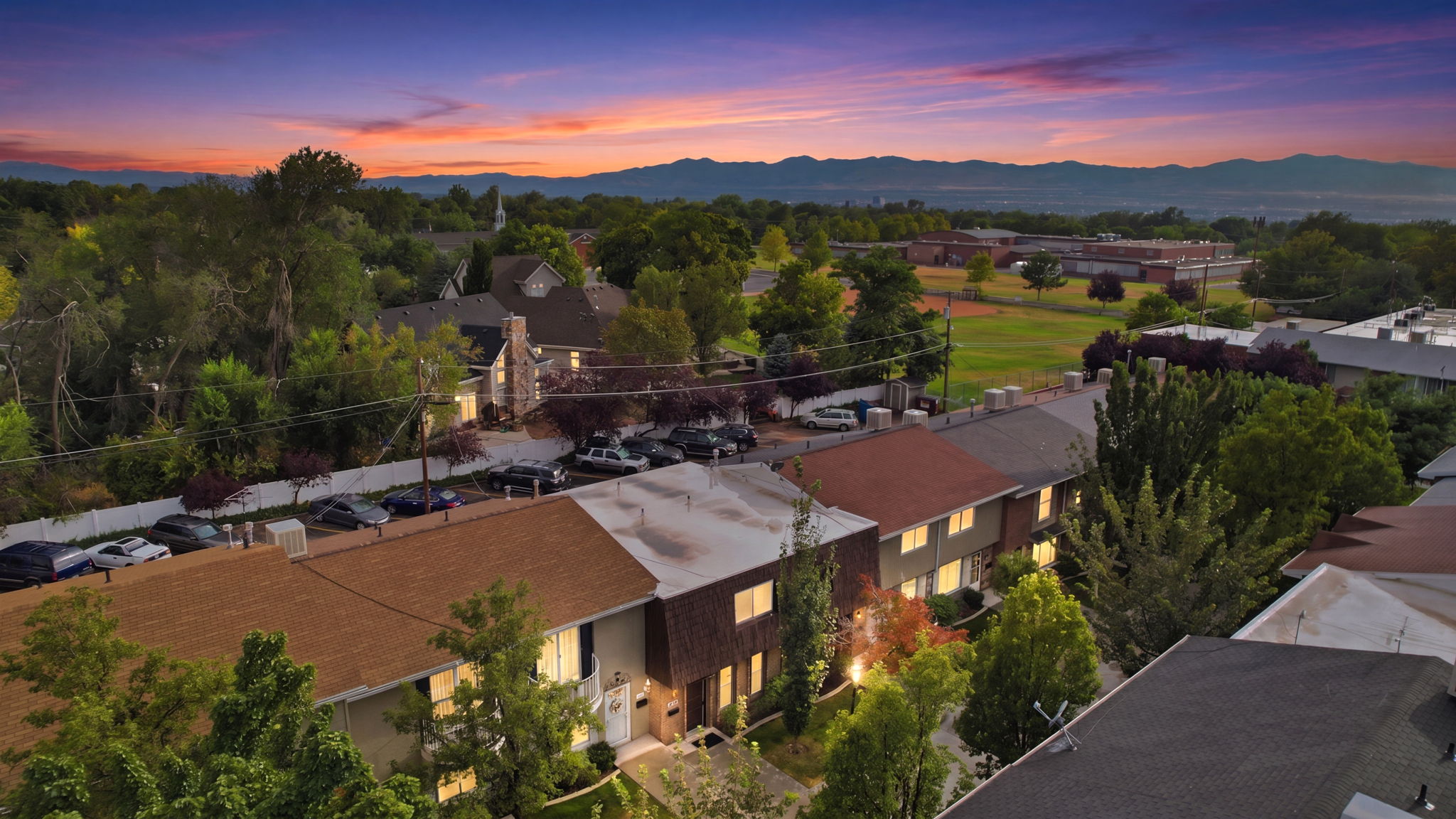 Townhome-style residences with pitched roofs and established tree canopy