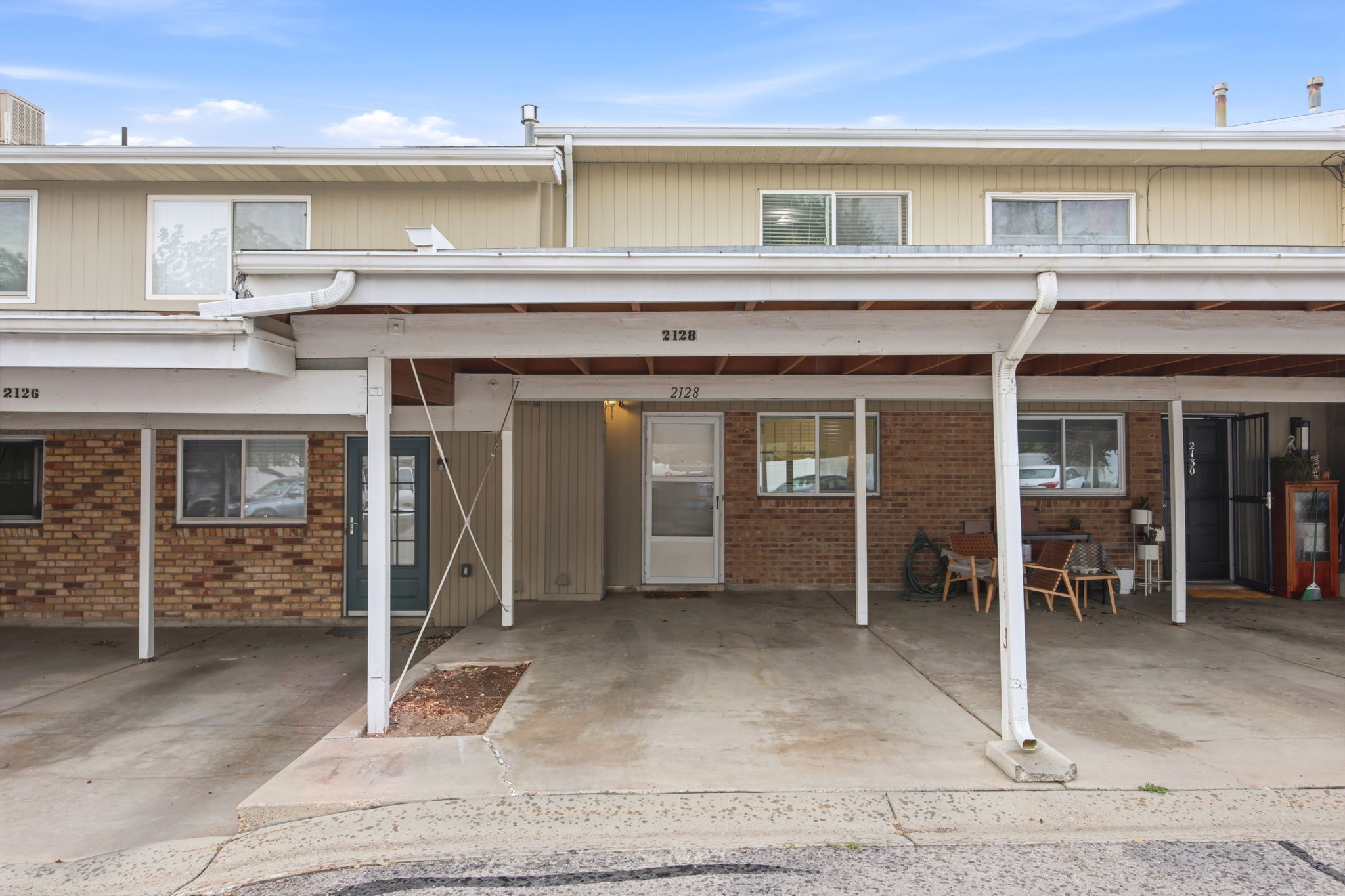 Multi-level townhome exterior featuring an integrated carport with concrete flooring